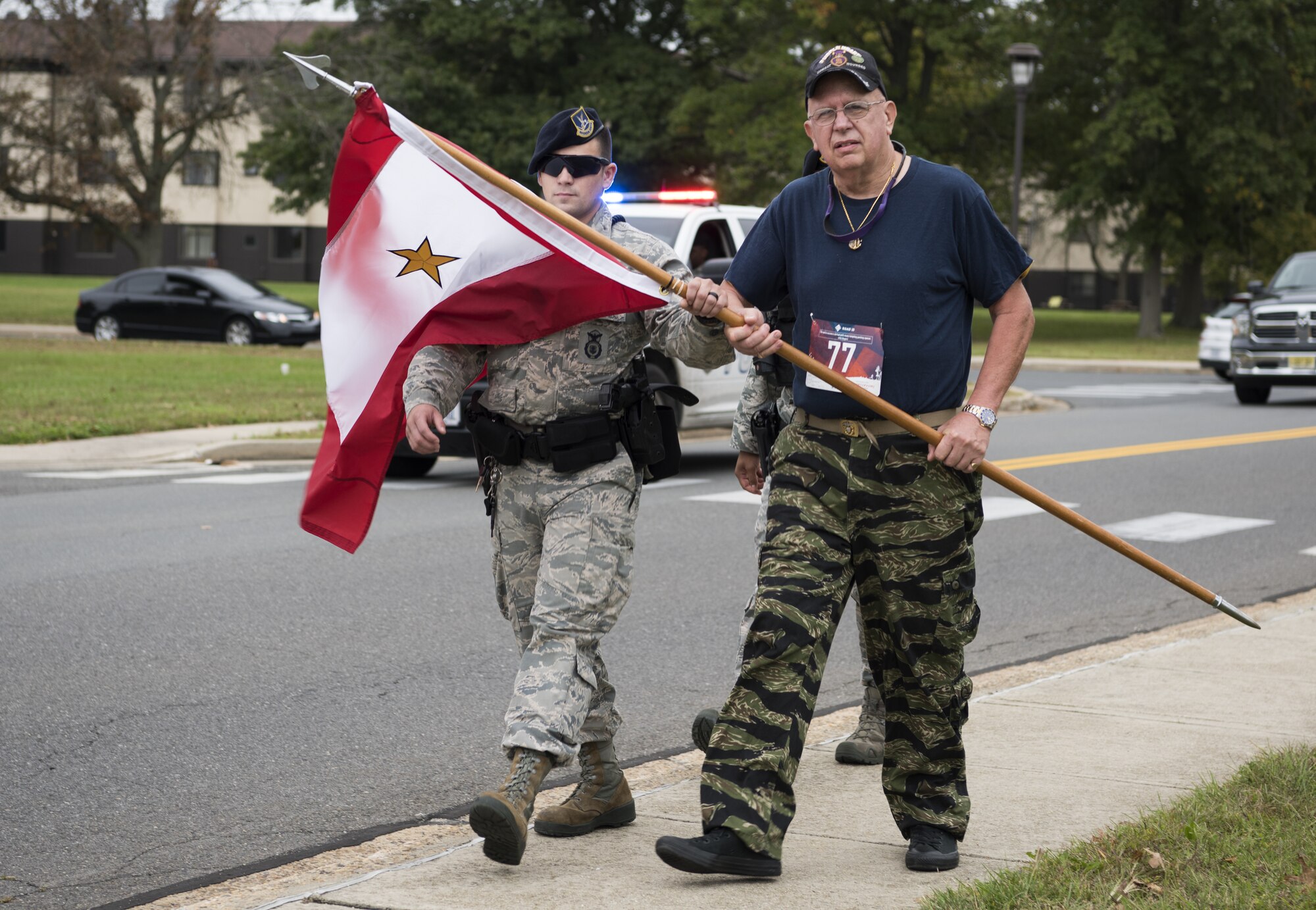 Paul Reuter, a Gold Star Families for Peace member and retired U.S. Navy lieutenant commander, carried the Gold Star flag across the finish line during the 12th Annual Gold Star Ruck March on Joint Base McGuire-Dix-Lakehurst, New Jersey, Oct. 6, 2018. Reuter was asked to carry the flag representing all fallen service members due to his prior service. (U.S. Air Force photo by Airman First Class Ariel Owings)