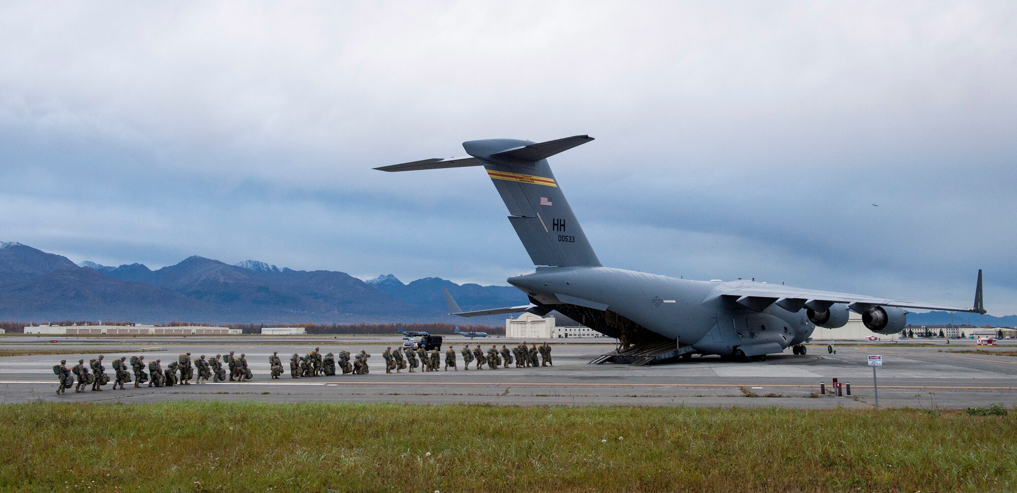 Army paratroopers from the 4th Infantry Brigade Combat Team (Airborne), 25th Infantry Division, U.S. Army Alaska, wait to board an Air Force C-17 Globemaster III, assigned to the 535th Airlift Squadron, out of Joint Base Pearl Harbor-Hickam, Hawaii, while participating in Arctic Anvil 19-01, at Joint Base Elmendorf-Richardson, Alaska, Oct. 9, 2018.