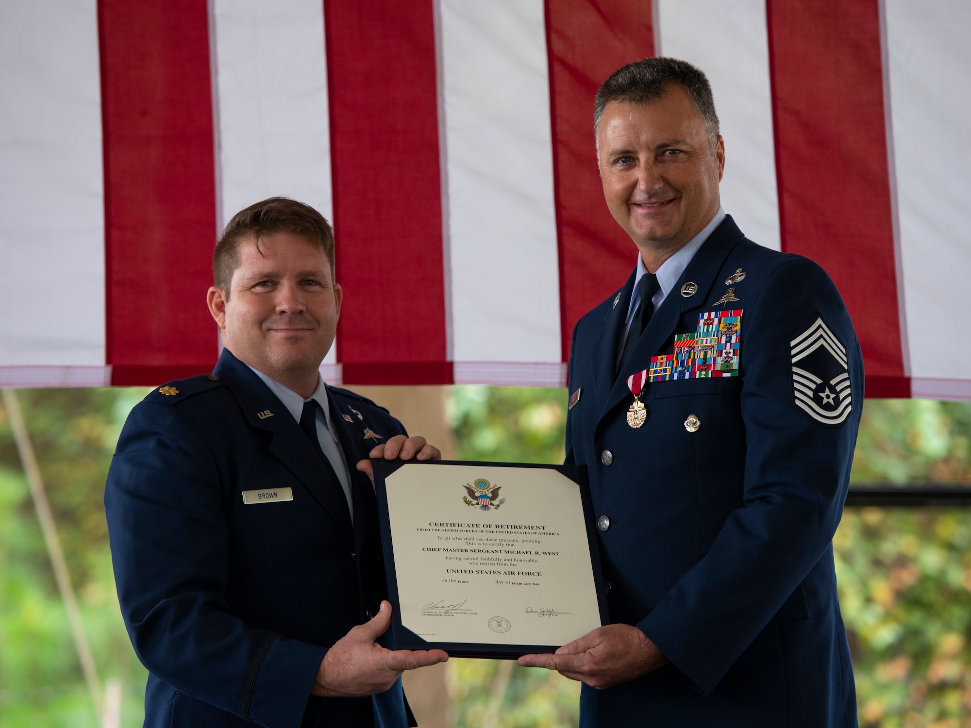 Maj. Gabriel Brown, left, director of operations with the Special Tactics Training Squadron, presents Chief Master Sgt. Michael West, a special tactics combat controller with the 24th Special Operations Wing, a certificate of retirement during a retirement ceremony at Hurlburt Field, Florida, Oct. 19, 2018.
