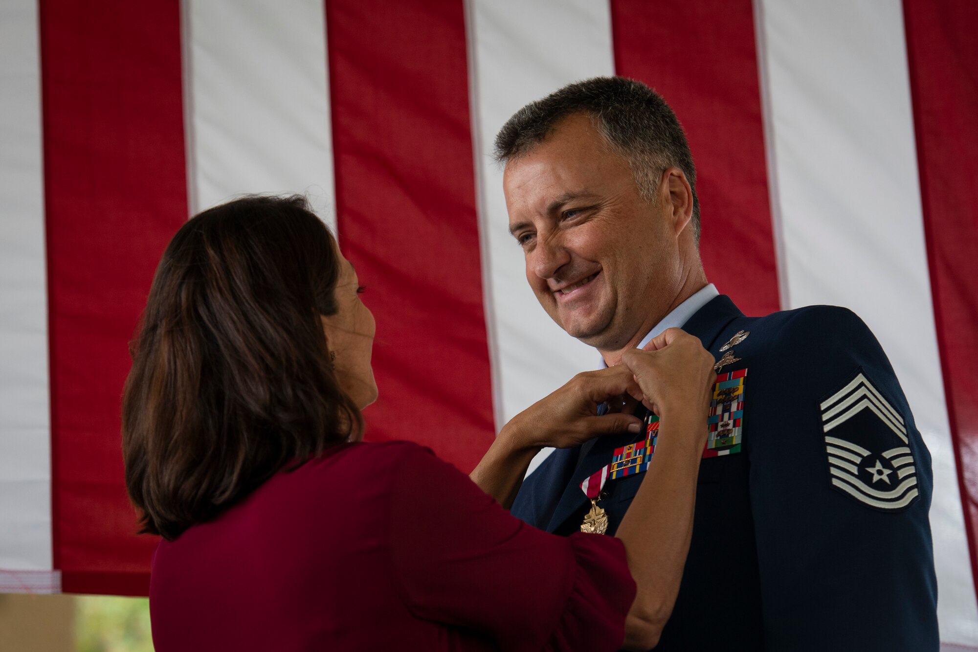 Chief Master Sgt. Michael West, right, a special tactics combat controller with the 24th Special Operations Wing, receives his retirement pin from his wife, Paola West, during a retirement ceremony at Hurlburt Field, Florida, Oct. 19, 2018.