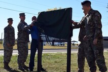 Col. Peter Bonetti, 341st Missile Wing vice commander; Col. Aaron Guill, 341st Security Forces Group commander; Chief Master Sgt. Eryn McElroy, 341st MW command chief; Master Sgt. Jason Seibel, 341st SFG training and scheduling superintendent, assembled in front of the Defenders Den, Oct. 17, 2018, at Malmstrom Air Force Base, Mont. The group officially opened the new 341st SFG building and heritage center by revealing the new building's sign. (U.S. Air Force photo by Kiersten McCutchan)