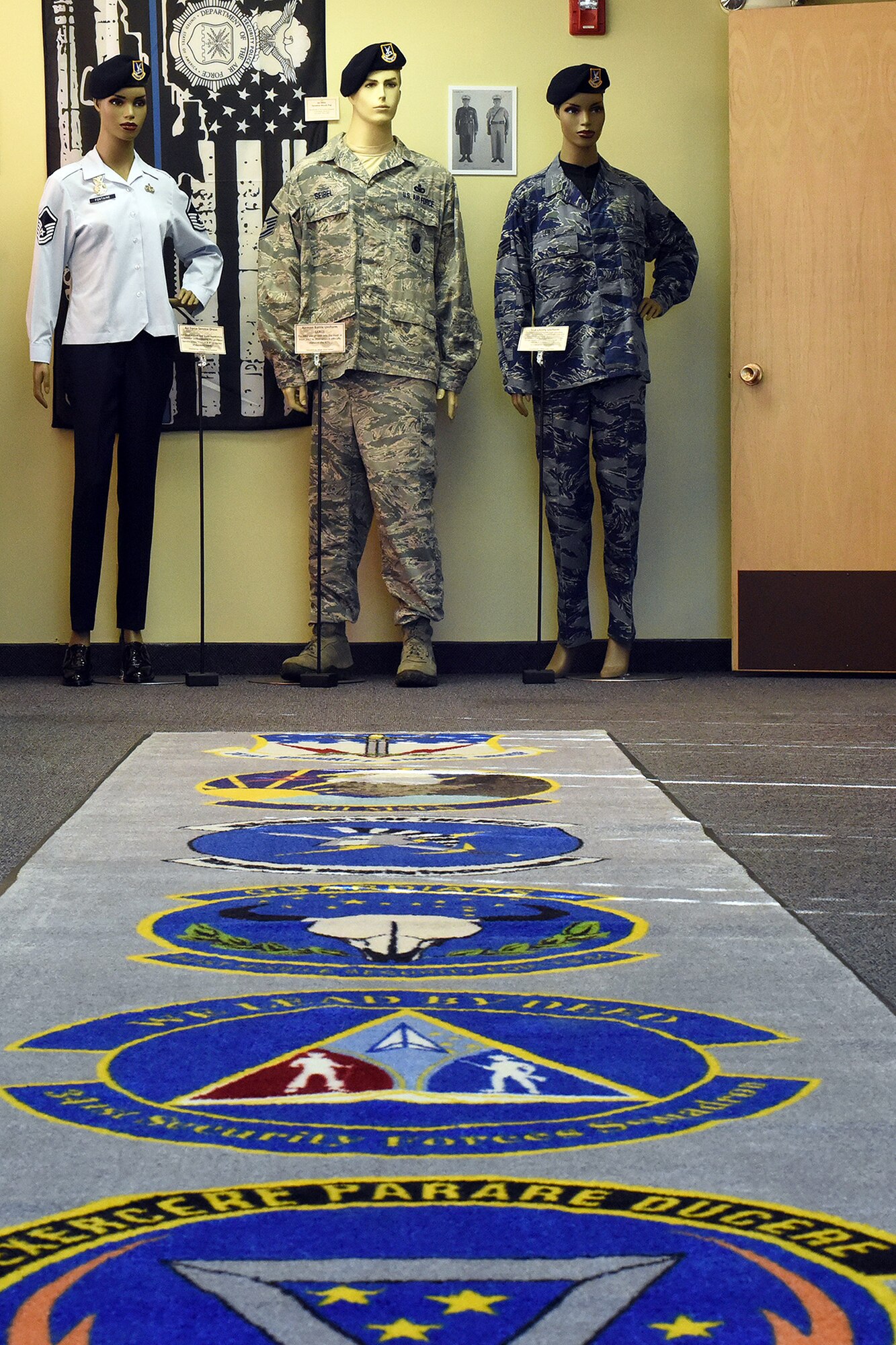 The 341st Security Forces Group officially opened the Defenders Den, a new building and heritage center, Oct. 17, 2018, at Malmstrom Air Force Base, Mont. When guests enter, they walk down the “red carpet” with each squadron patch and the group crest and find heritage memorabilia on the walls around. (U.S. Air Force photo by Kiersten McCutchan)