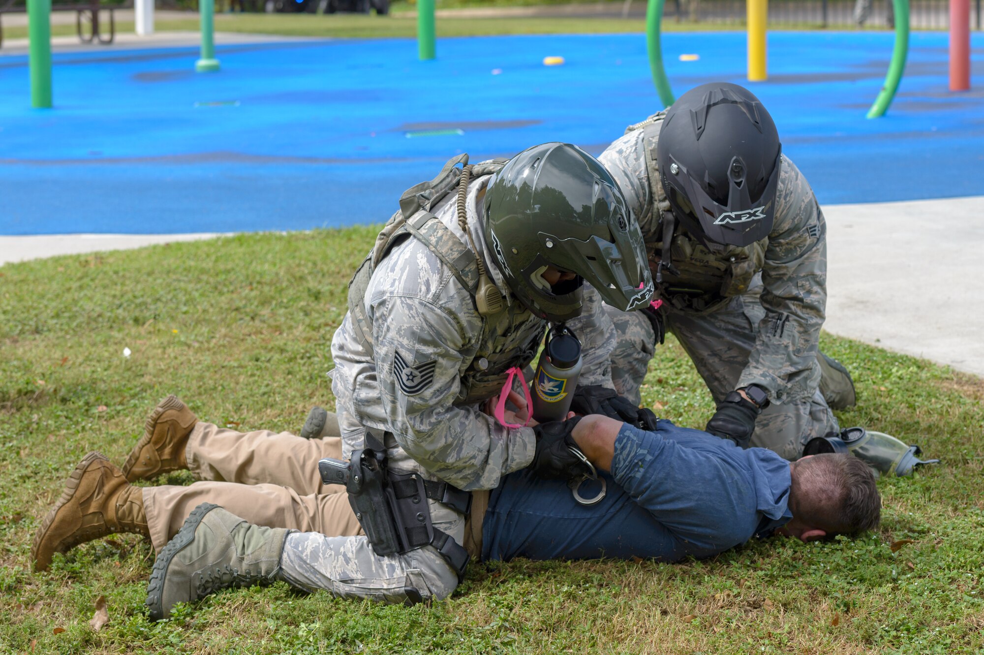 Members of the 81st Security Forces Squadron apprehend a terrorist role player during the Anti-Terrorism, Force Protection Condition and Chemical, Biological, Radiological, Nuclear and high-yield Explosives training exercise at the Marina at Keesler Air Force Base, Mississippi, Oct. 17, 2018. The AT/FPCON/CBRNE exercise was conducted to evaluate the mission readiness and security of Keesler. (U.S. Air Force photo by Andre' Askew)