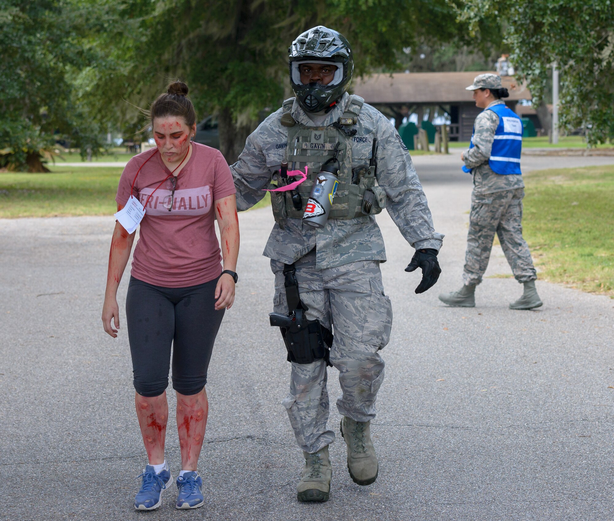 U.S. Air Force Airman 1st Class Danieli Rivera, 81st Logistic Readiness Squadron vehicle operator, portrays a "victim" being escorted to the decontamination area by Tech. Sgt. Jason Gavin, 81st Security Forces Squadron investigator, during the Anti-Terrorism, Force Protection Condition and Chemical, Biological, Radiological, Nuclear and high-yield Explosives training exercise at the Marina at Keesler Air Force Base, Mississippi, Oct. 17, 2018. The AT/FPCON/CBRNE exercise was conducted to evaluate the mission readiness and security of Keesler. (U.S. Air Force photo by Andre' Askew)