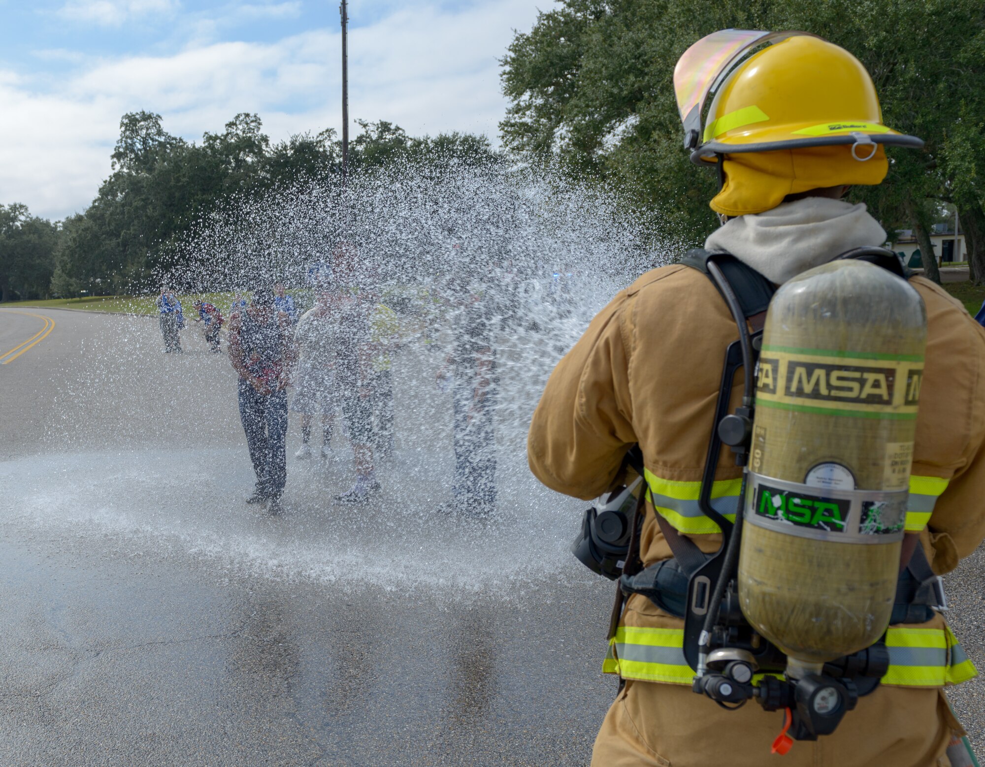 A Keesler firefighter guides "victims" through a gross decontamination site during the Anti-Terrorism, Force Protection Condition and Chemical, Biological, Radiological, Nuclear and high-yield Explosives training exercise at the Marina at Keesler Air Force Base, Mississippi, Oct. 17, 2018. The AT/FPCON/CBRNE exercise was conducted to evaluate the mission readiness and security of Keesler. (U.S. Air Force photo by Andre' Askew)