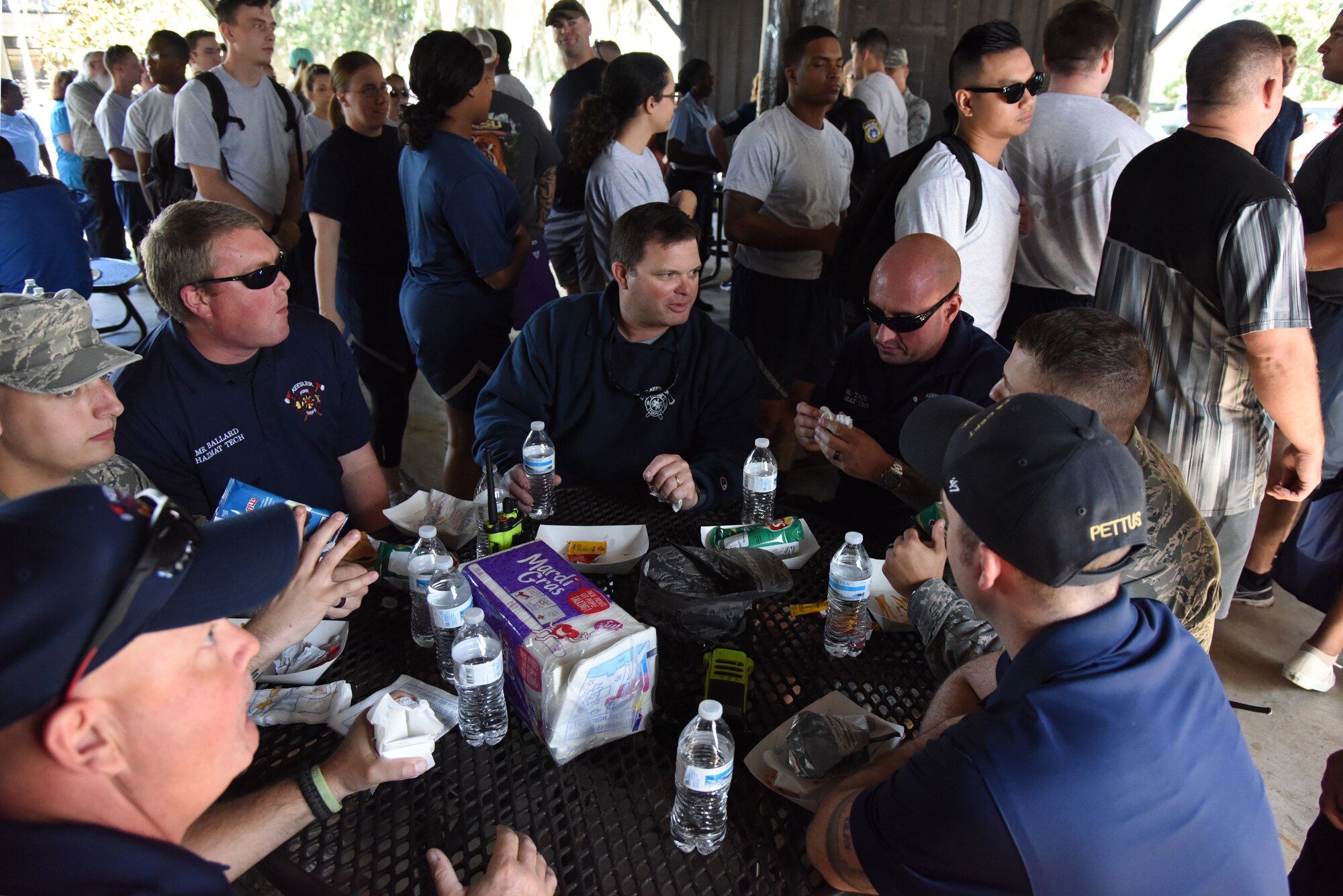 Members of the Keesler Fire Department eat lunch during Wingman Day at the Marina on Keesler Air Force Base, Mississippi, Oct. 18, 2018. Wingman Day focused on the physical domain, resiliency and team-building initiatives across the base followed by a barbeque and games at the Marina. (U.S. Air Force photo by Kemberly Groue)