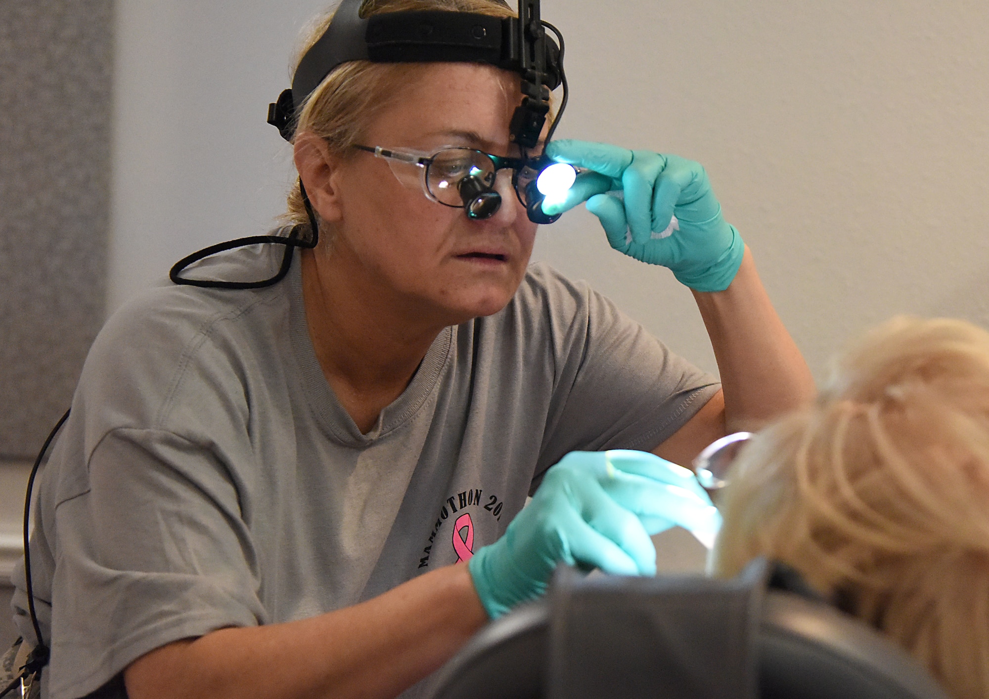 U.S. Air Force Lt. Col. Jill Cherry, 81st Dental Squadron general dentist, administers an exam during the 7th Annual Mammothon Cancer Screening and Preventative Health Fair inside the Don Wylie Auditorium on Keesler Air Force Base, Mississippi, Oct. 19, 2018. The 81st Medical Group hosted the walk-in event which included screenings for multiple types of cancer and chronic diseases in honor of Breast Cancer Awareness Month. (U.S. Air Force photo by Kemberly Groue)