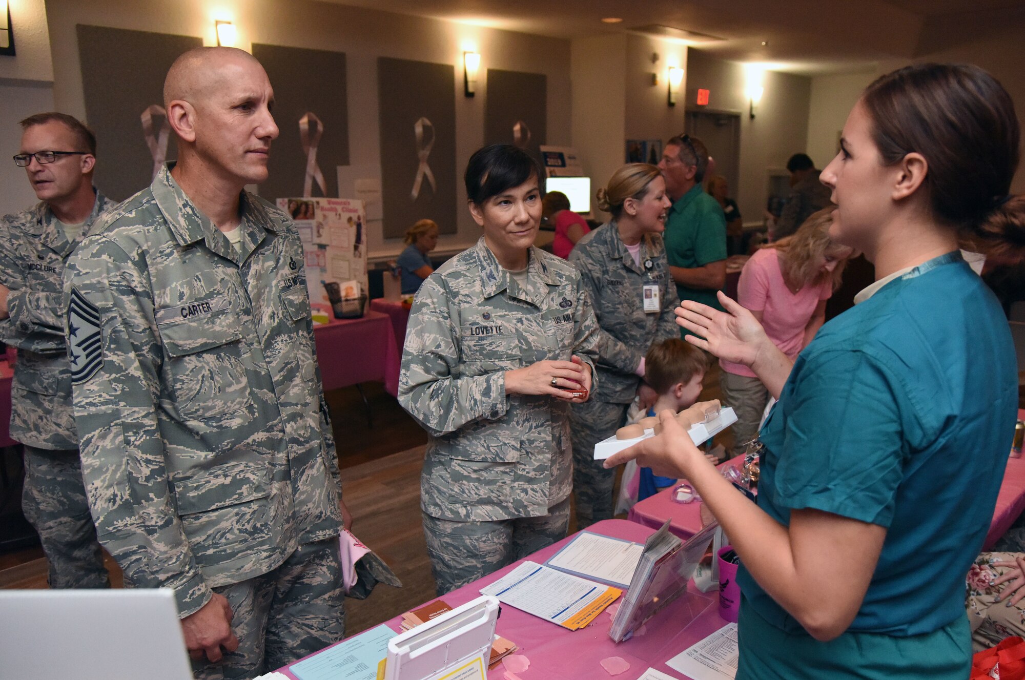 U.S. Air Force Staff Sgt. Hallie Neel, 81st Surgical Operations Squadron urology technician, provides a brief urology overview to Chief Master Sgt. Kenneth Carter, 81st Training Wing command chief, and Col. Debra Lovette, 81st TRW commander, during the 7th Annual Mammothon Cancer Screening and Preventative Health Fair inside the Don Wylie Auditorium on Keesler Air Force Base, Mississippi, Oct. 19, 2018. The 81st Medical Group hosted the walk-in event which included screenings for multiple types of cancer and chronic diseases in honor of Breast Cancer Awareness Month. (U.S. Air Force photo by Kemberly Groue)