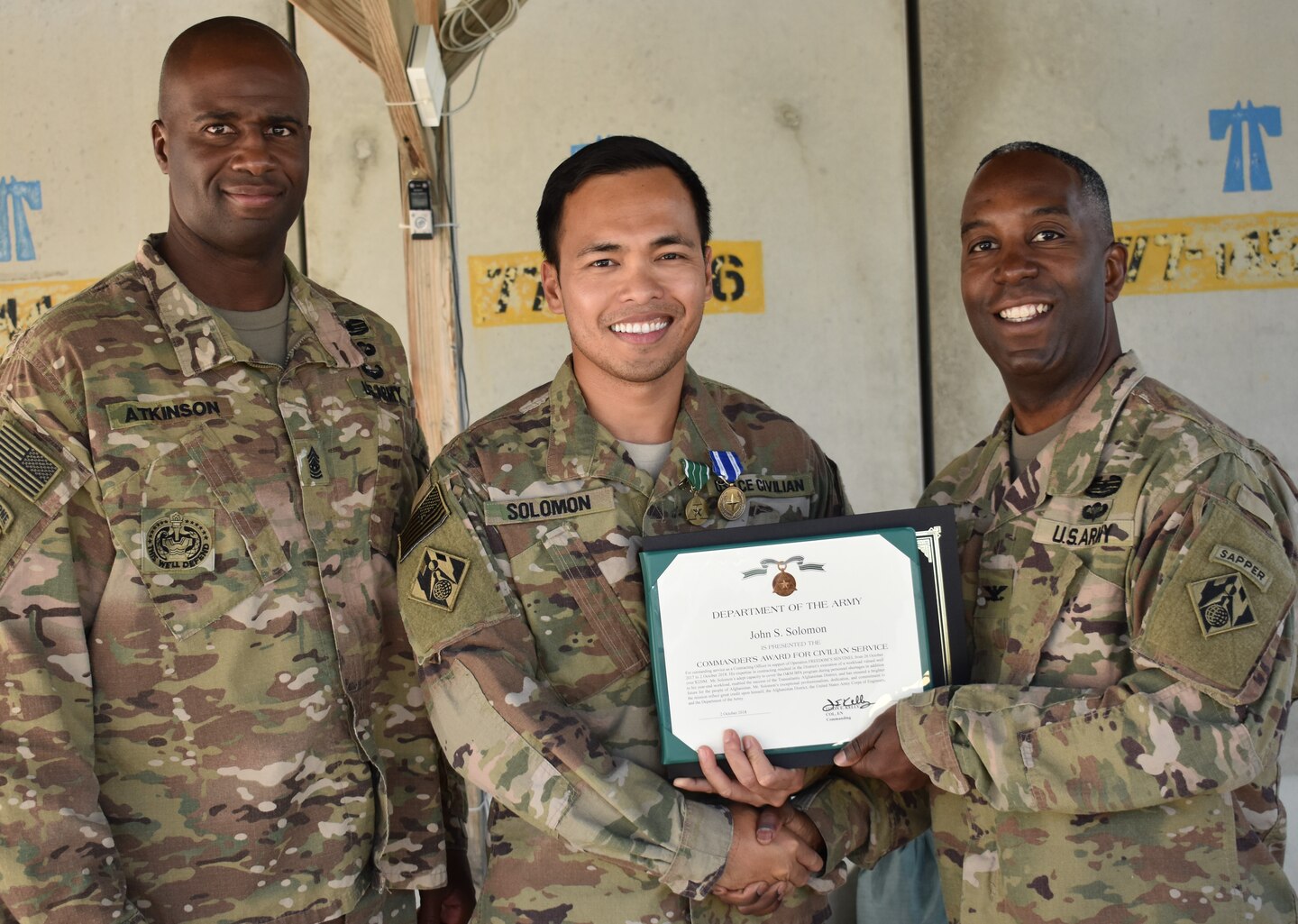 Command Sergeant Major Nathaniel Atkinson joins John S. Solomon as he receives his NATO and Commander’s Award for Civilian Service from Afghanistan District Commander, Jason Kelly.