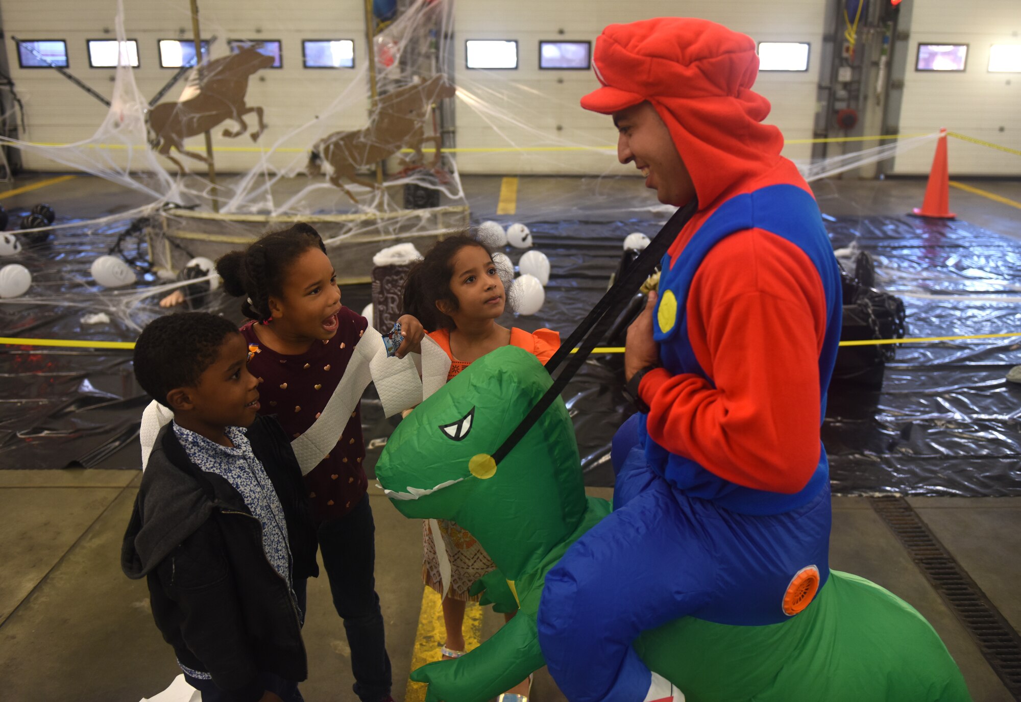 A Team Mildenhall volunteer and children socialize during a Halloween-themed Hearts Apart event Oct. 18, 2018, on RAF Mildenhall, England. The monthly Hearts Apart dinners are a way for spouses and family members of deployed Airmen to gather together and connect. (U.S. Air Force photo by Airman 1st Class Brandon Esau)