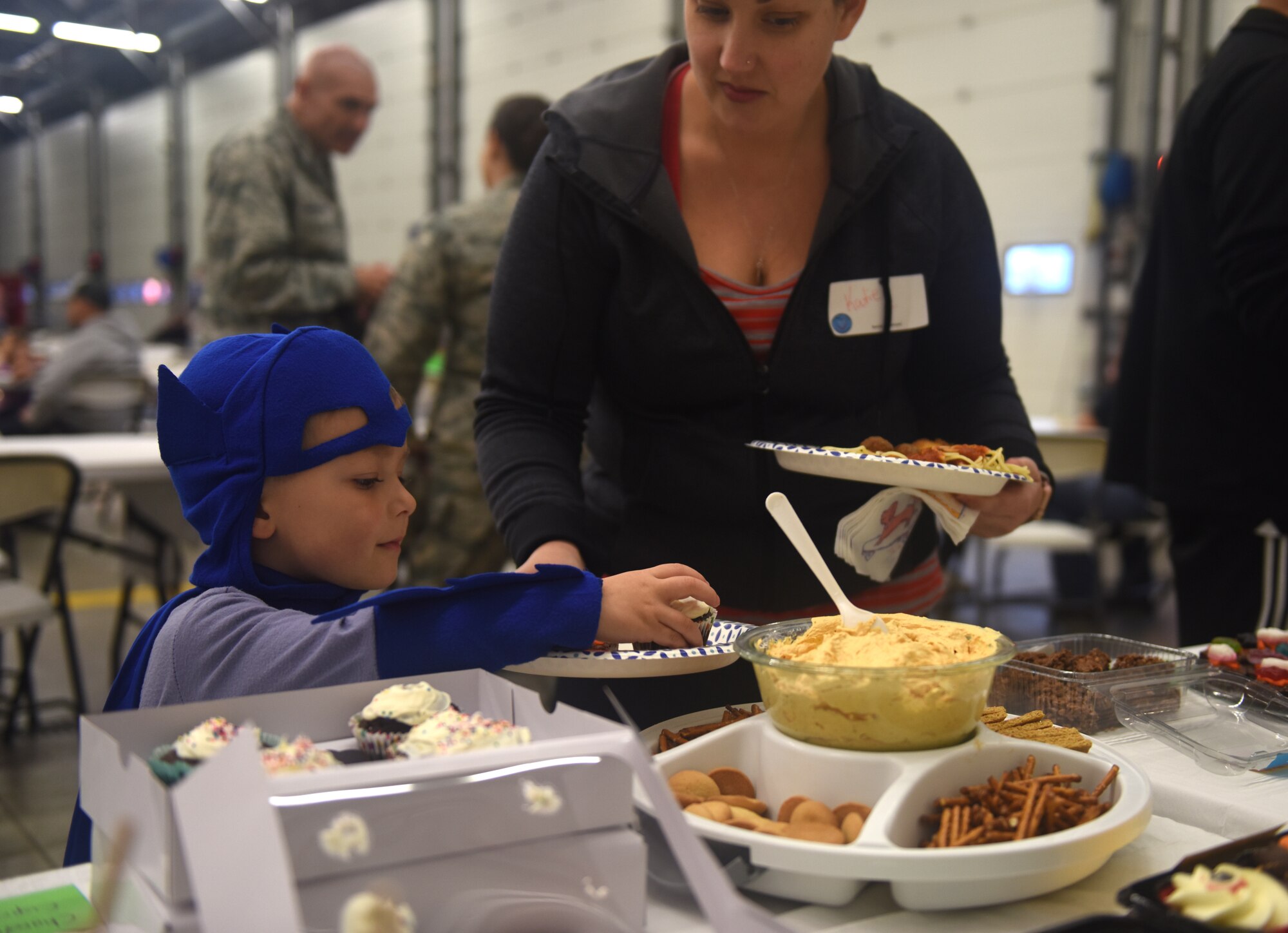 The son of a deployed Team Mildenhall Airman places a cupcake on his plate during a Hearts Apart event Oct. 18, 2018, on RAF Mildenhall, England. The event was hosted by the 100th Civil Engineering Squadron along with the Mildenhall Key Spouses’ Club. Families enjoyed food, games and a Halloween costume contest. (U.S. Air Force photo by Airman 1st Class Brandon Esau)