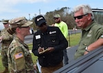 Captain Sha-Raya Bates, commander of the Washington, Ga.-based 214th Forward Support Company discusses operations at a point of distribution in Seminole County with County Commissioner Darius Culverson. The 1214th has supported relief operations in hurricane impacted counties in Ga. since mobilizing October 11.