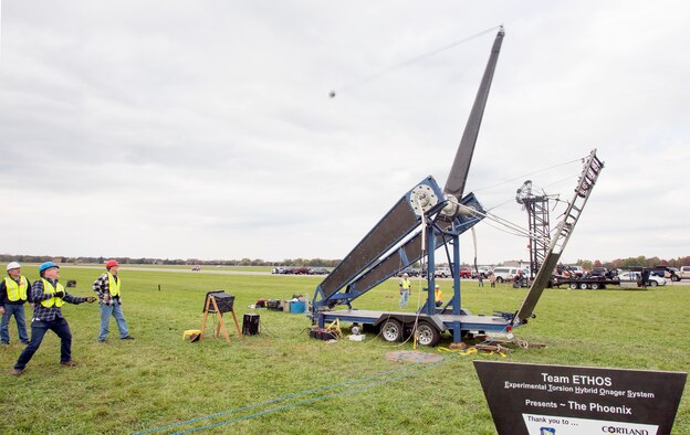 David Mollenhauer, in blue hardhat, Team ETHOS team captain, pulls the trigger of The Phoenix launching a 10-pound pumpkin downrange at the end of the 13th annual Wright-Patterson Air Force Base, Ohio, Pumpkin Chuck, Oct. 27, 2017.