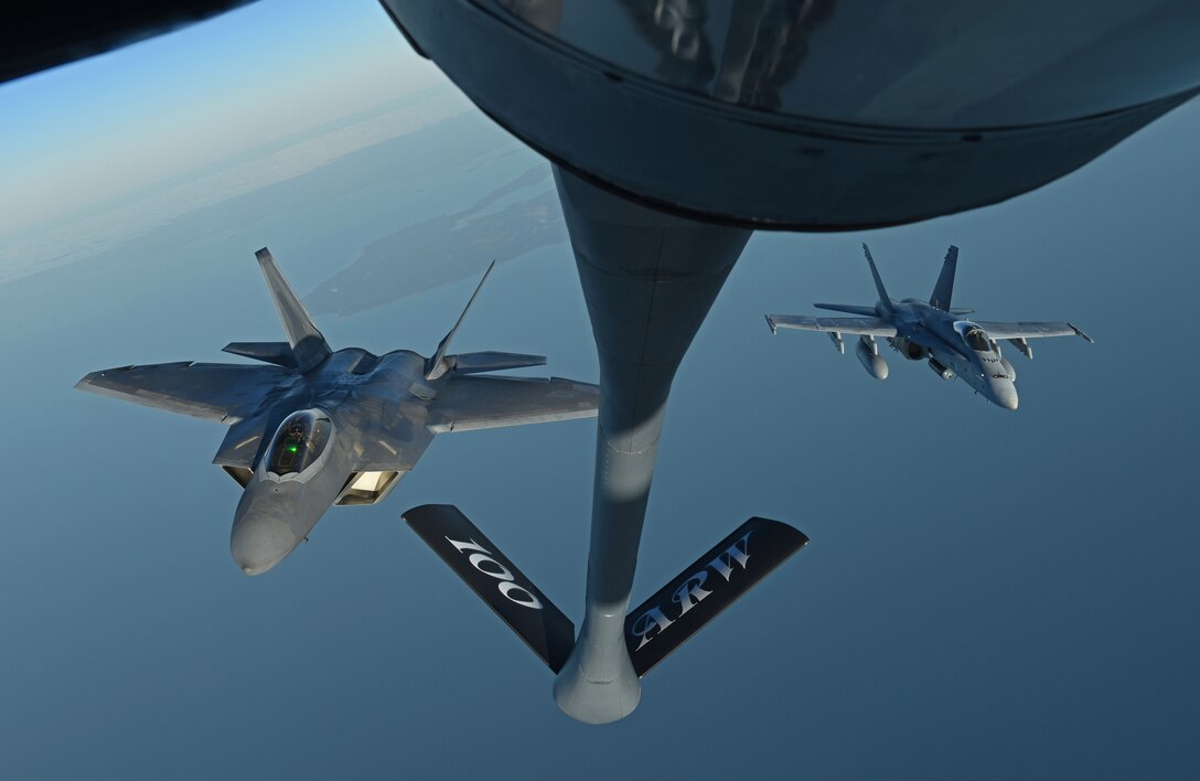 A U.S. Air Force F-22 Raptor and a Finnish air force F/A-18 Hornet fly behind a U.S. Air Force KC-135 Stratotanker during training off the coast of Finland, Oct 19, 2018. The Raptors deployed from the 27th Fighter Squadron, Joint Base Langley-Eustis, Va. and arrived in Europe Oct. 5. The F-22s trained with different NATO allies and partners to deter potential threats and increase regional security. (U.S. Air Force photo by Senior Airman Luke Milano)