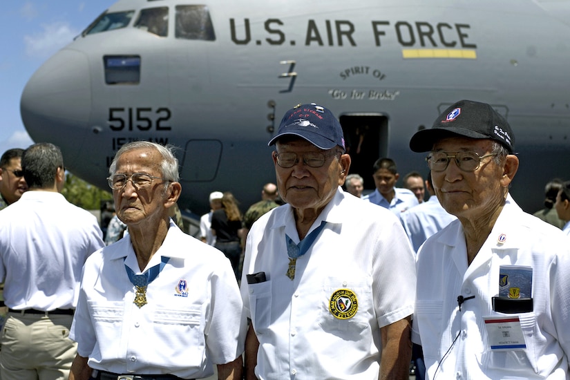 Three World War II veterans stand in front of Air Force cargo plane