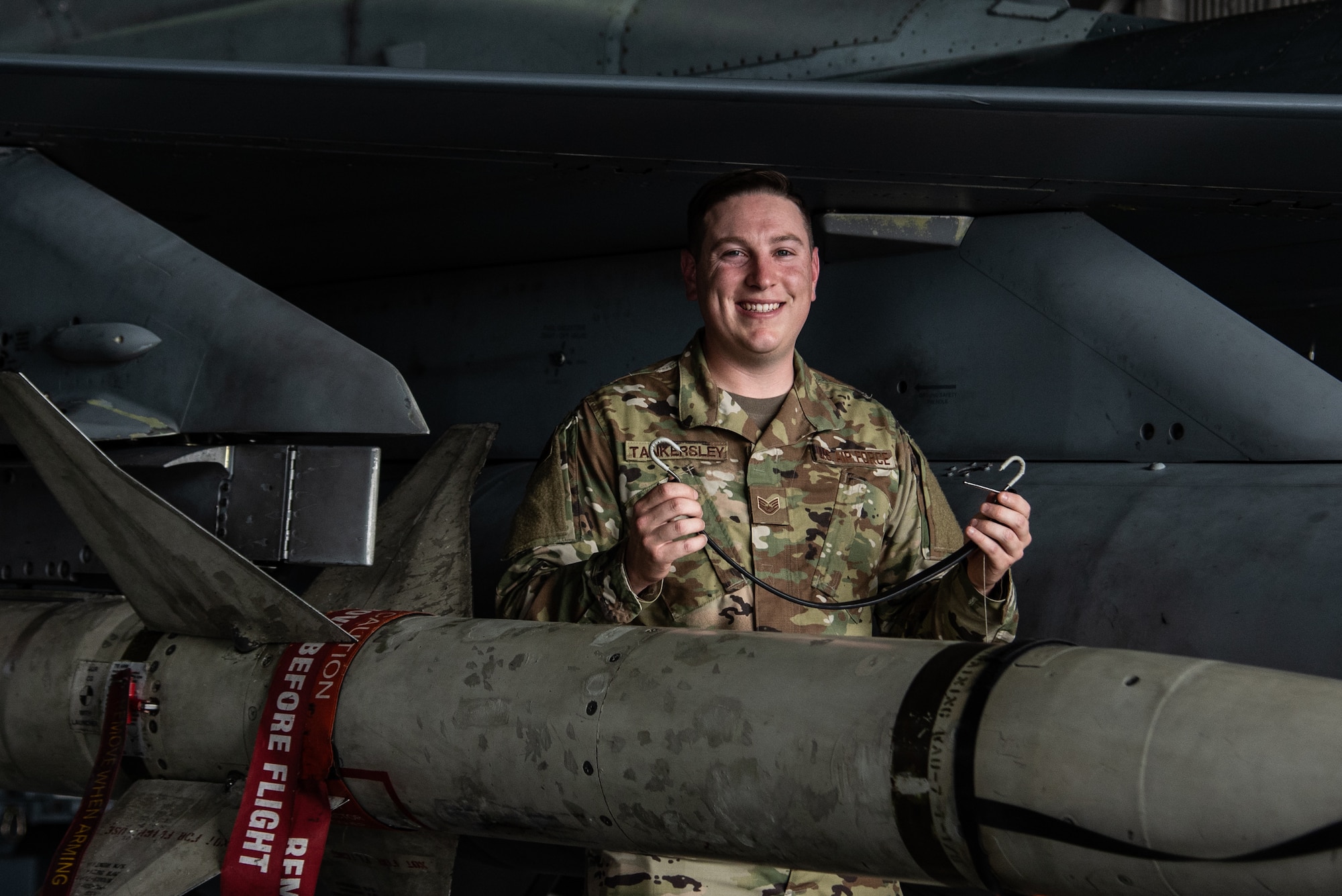 U.S. Air Force Staff Sgt. Justin Tankersley, 20th Maintenance Group weapons lead crew chief, holds up the tool he invented to save the Air Force time and money at Shaw Air Force Base, S.C., Oct. 16, 2018.