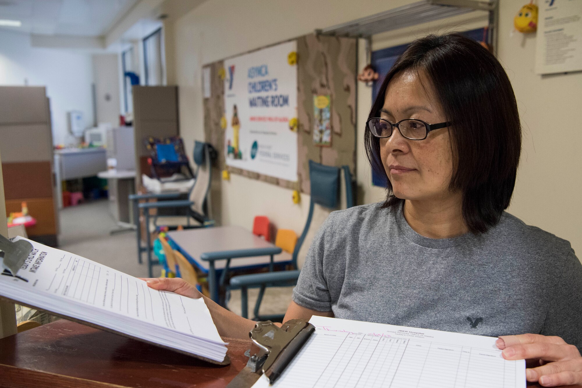 Misono Berry, a Children’s Waiting Room child specialist, prepares registration forms and sign-in logs for the Children’s Waiting Room at Joint Base Elmendorf-Richardson, Alaska, Oct. 18, 2018. The program offers parents with hospital appointments a safe, no-cost, temporary child care solution for children ages 6 weeks to 12 years old.