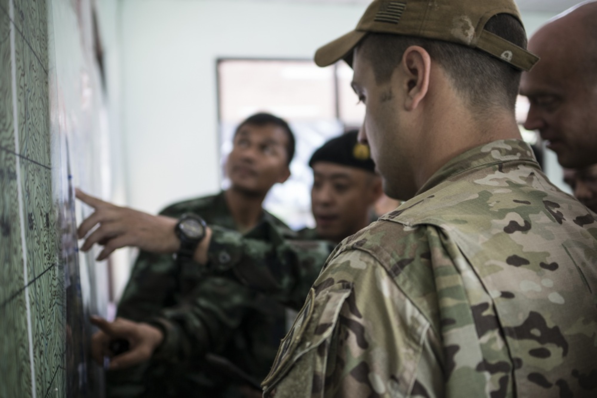 Airmen from the U.S. Indo-Pacific Command (USINDOPACOM) examine a map with Royal Thai military officials June 29, 2018, at Chiang Rai, Thailand. The United States, through USINDOPACOM, sent a search and rescue team to Tham Luang cave in Northern Thailand at the request of the Royal Thai government to assist in the rescue of the missing Thai soccer players and their coach. (U.S. Air Force photo by Capt. Jessica Tait)