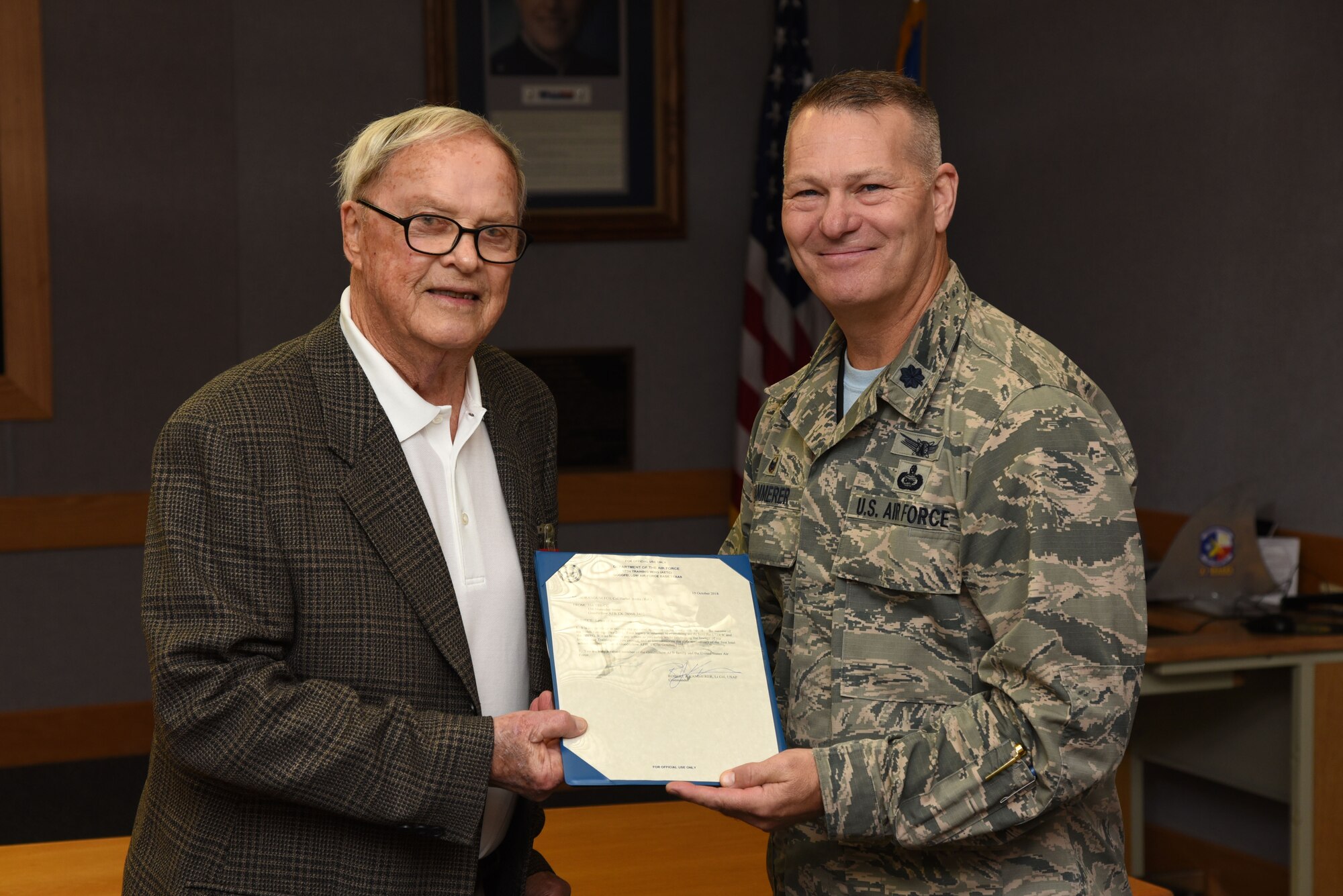 Retired U.S. Air Force Col. Harlan Bruha, former Air Force School of Applied Cryptologic Sciences commander, receives an award from Lt. Col. Robert Kammerer, 316th Training Squadron commander, during the 60-year anniversary of intelligence training in the Piper Auditorium at Sebers Hall on Goodfellow Air Force Base, Oct. 19, 2018. Bruha received recognition for his contributions to the intelligence field and the 316th TRS. (U.S. Air Force photo by Staff Sgt. Joshua Edwards/Released)