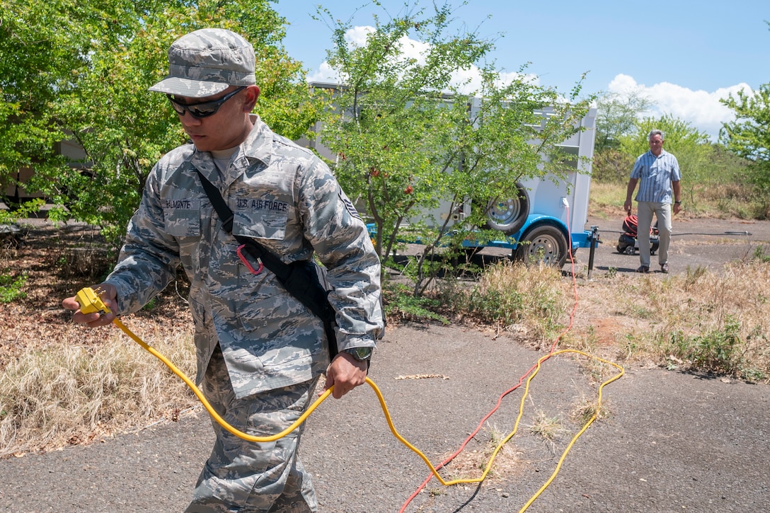 Master Sgt. Bobbyjo Balmonte, 154th Medical Group Detachment 1, Medical Logistics NCO in charge, runs a power cable from a mobile, 5-kW hydrogen fuel cell generator