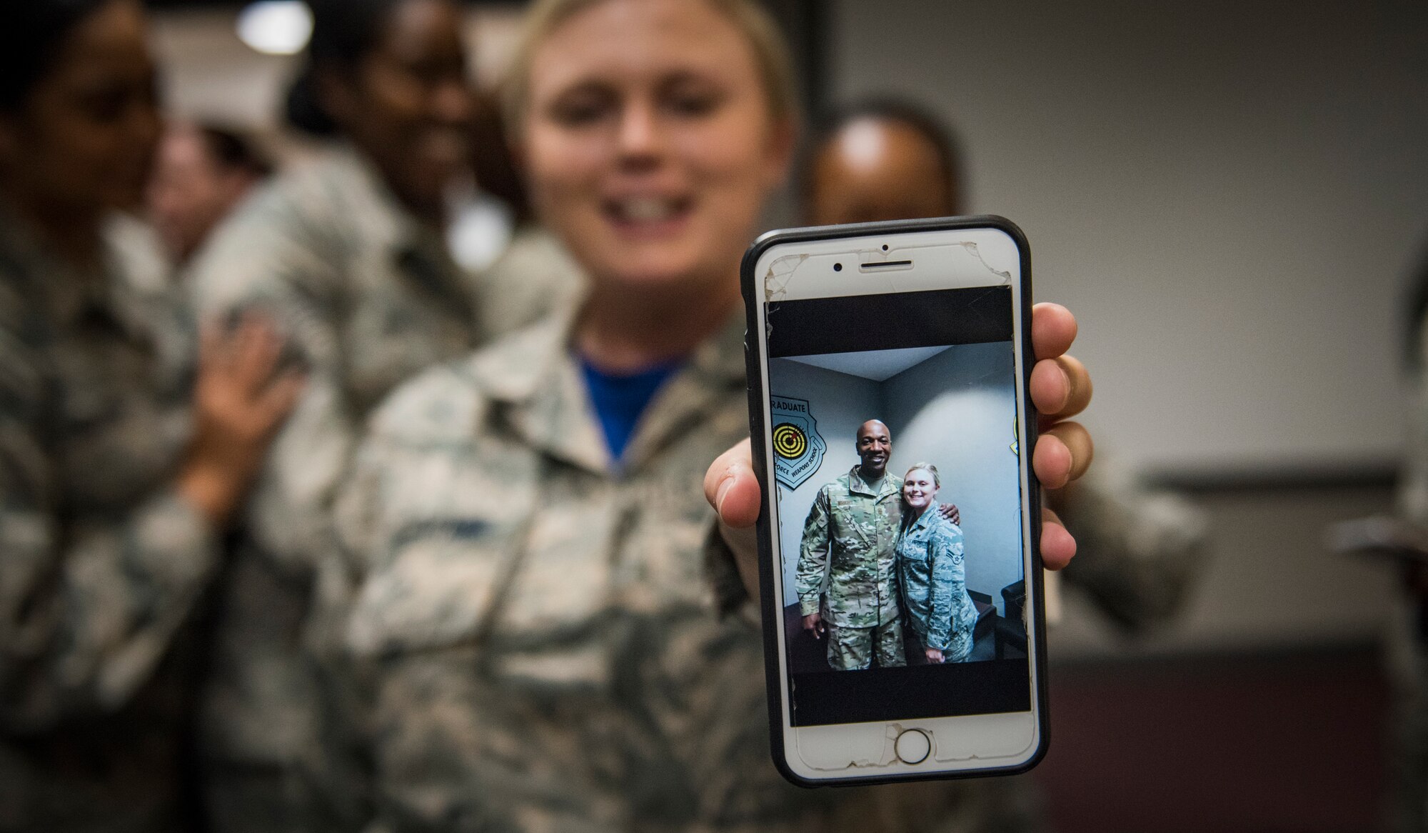 An Airman shows off her picture with Chief Master Sgt. of the Air Force Kaleth O. Wright Oct. 19, 2018, at Nellis Air Force Base, Nevada. Wright met with Airmen from all around the base. (U.S. Air Force photo by Airman 1st Class Andrew D. Sarver)