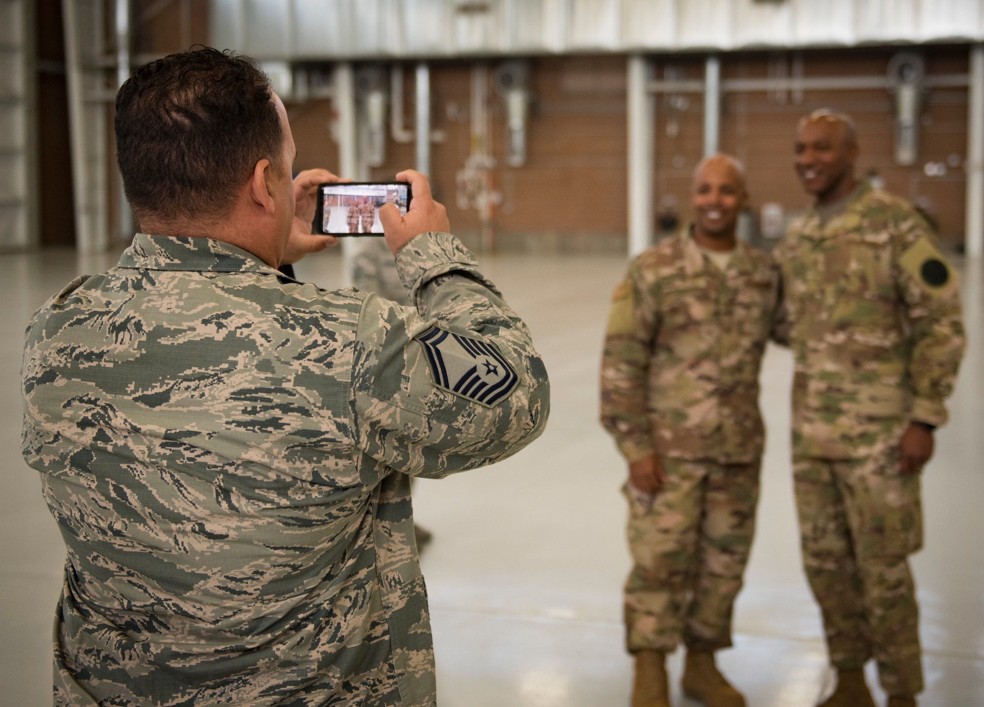 An Airman poses for a photo with Chief Master Sgt. of the Air Force Kaleth O. Wright during a base tour Oct. 19, 2018, at Nellis Air Force Base, Nevada. After speaking with multiple units across Nellis, dozens of Airmen lined up to get a photo with Wright. (U.S. Air Force photo by Airman 1st Class Andrew D. Sarver)