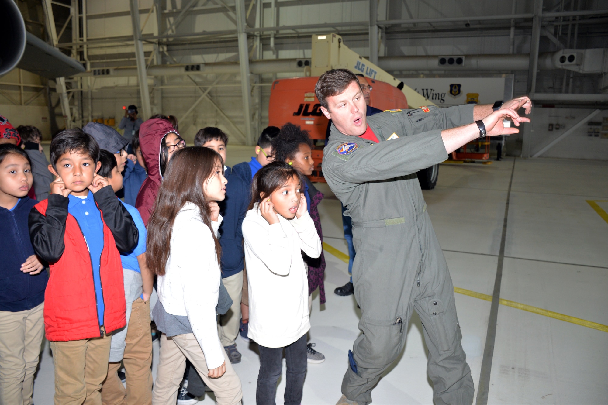 Tech. Sgt. Kevin D. Meredith, 68th Airlift Squadron flight engineer, explains how the nose of a C-5M Super Galaxy opens to accommodate loading cargo to third-grade students from Meredith Baskin Elementary Oct. 19, 2018 at Joint Base San Antonio-Lackland.