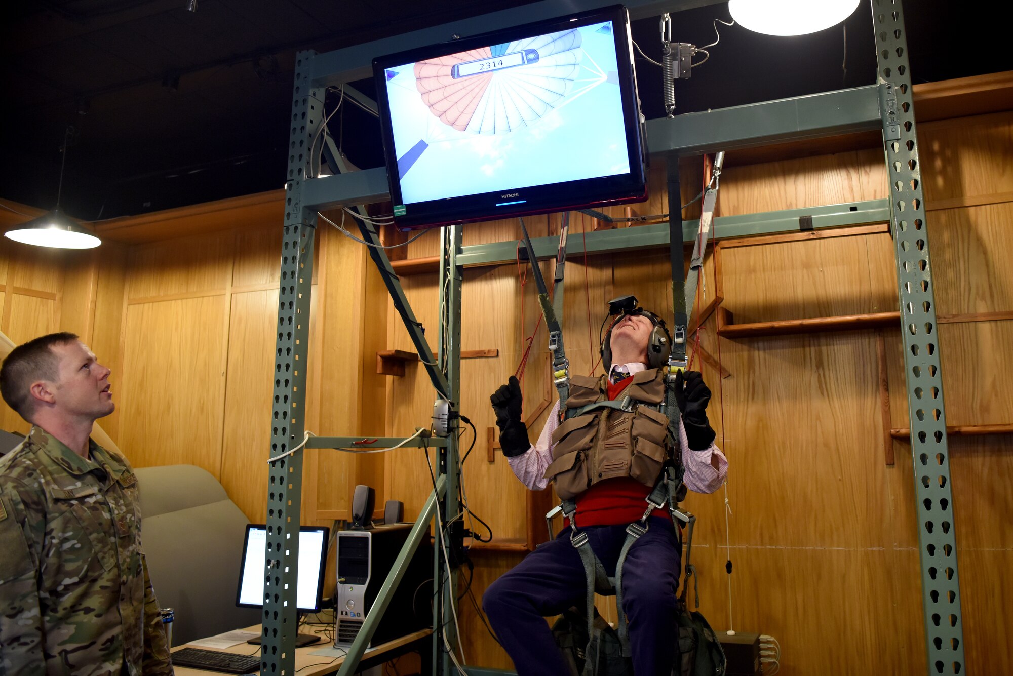 Charles Watt, High Sheriff of Norfolk, checks a parachute on a training simulator at the 48th Operations Support Squadron Survival, Evasion, Resistance and Escape facility at Royal Air Force Lakenheath, England, Oct. 19, 2018. The High Sheriffs toured a flight simulator, a parachute simulator, the aircraft control tower, an F-15E Strike Eagle static display and the Aerospace Propulsion shop at RAF Lakenheath. (U.S. Air Force Photo/ Senior Airman John A. Crawford)