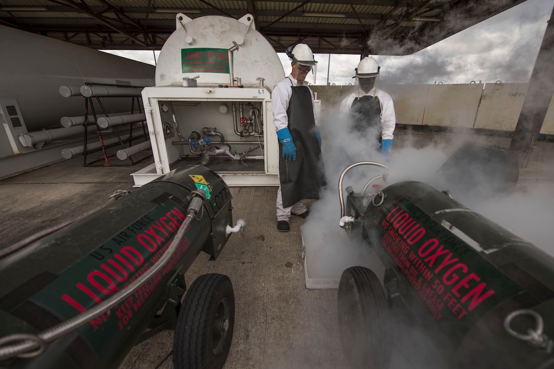 U.S. Air Force Tech Sgt. Jassen Manrrique, 100th Logistics Readiness Squadron NCO-in-charge of fuels facilities, and Senior Airman Kameron Ware, 100th LRS Fuels Facilities operator, service liquid oxygen carts at RAF Mildenhall, England, Oct. 12, 2018. Facilities Airmen wear protective equipment while testing liquid oxygen due to the low temperature of - 297 degrees Fahrenheit. (U.S. Air Force photo by Staff Sgt. Christine Groening)