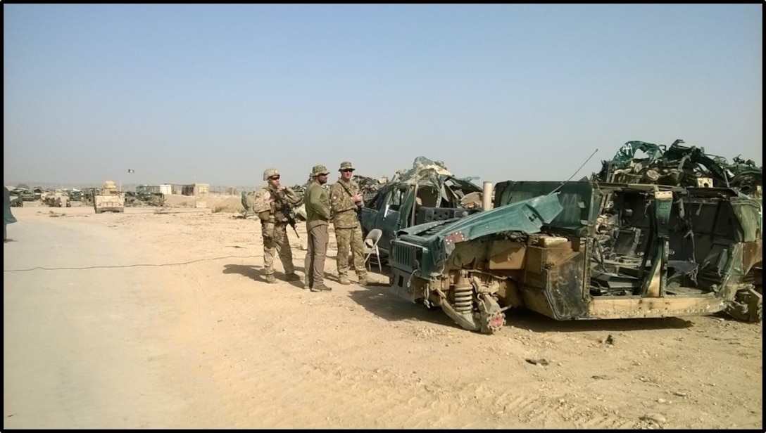 Team members wait for trucks to arrive to haul away vehicles processed into scrap material.