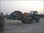 The team uses heavy equipment to moves damaged vehicles to the shearing area.
