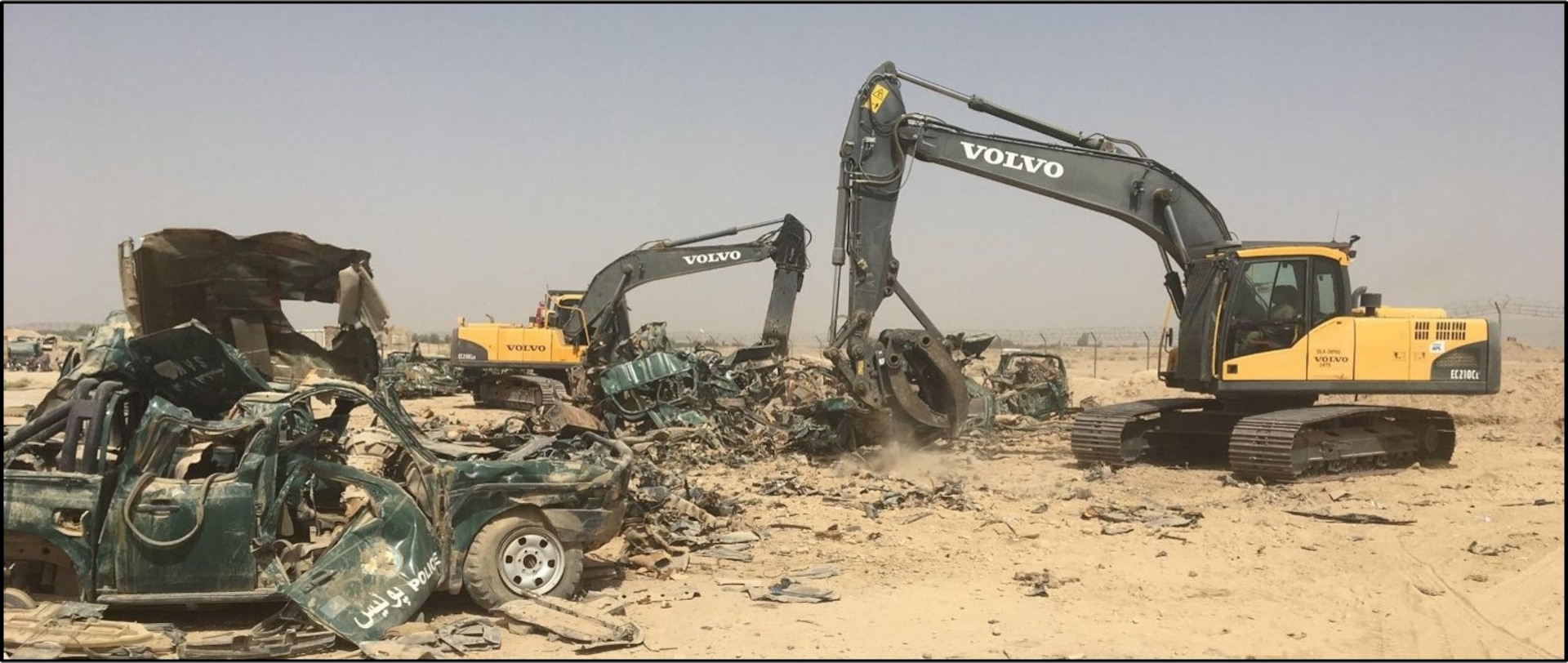 An excavator is used to help crush and stockpile vehicles to be processed as scrap.