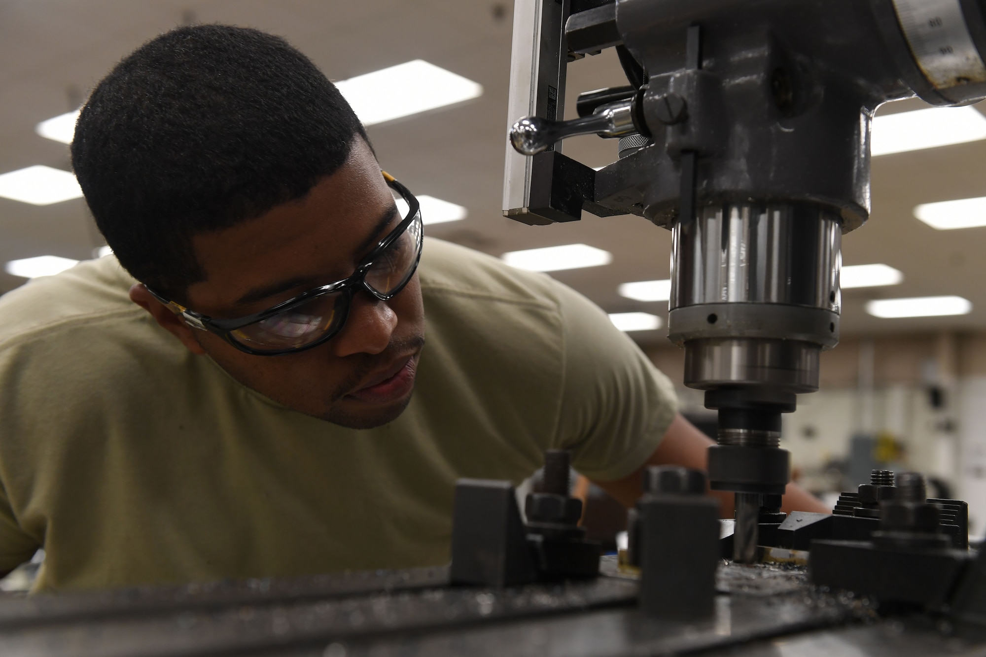 A man looks at a machining tool.