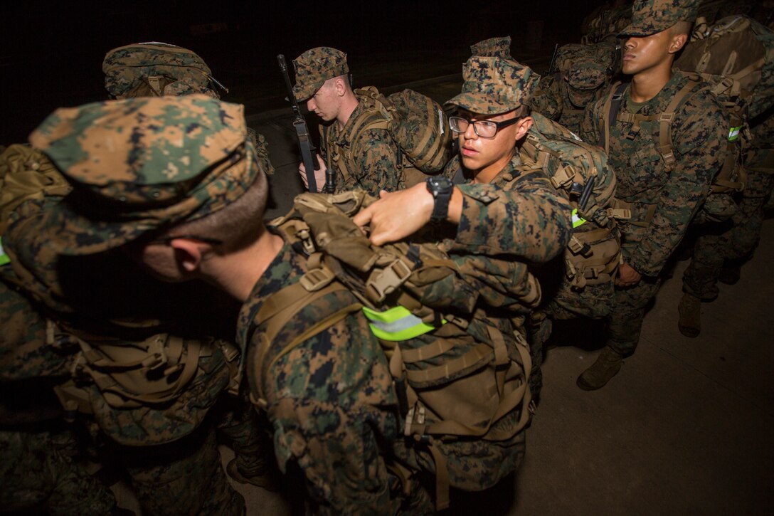 Naval Reserve Officers Training Corps Midshipmen from Tulane University, Southern Univerity and Platoon Leadership Course check each others packs before a 10 kilometer hike around an Armed Forces Reserve Center in Baton Rouge, La., October 20, 2018. Marines from Marine Forces Reserve, in New Orleans, assisted in the hike to provide personal experiences and motivation for midshipman to better prepare them for Officer Candidate School and for their future military careers. (U.S. Marine Corps photo by Cpl. Niles Lee)