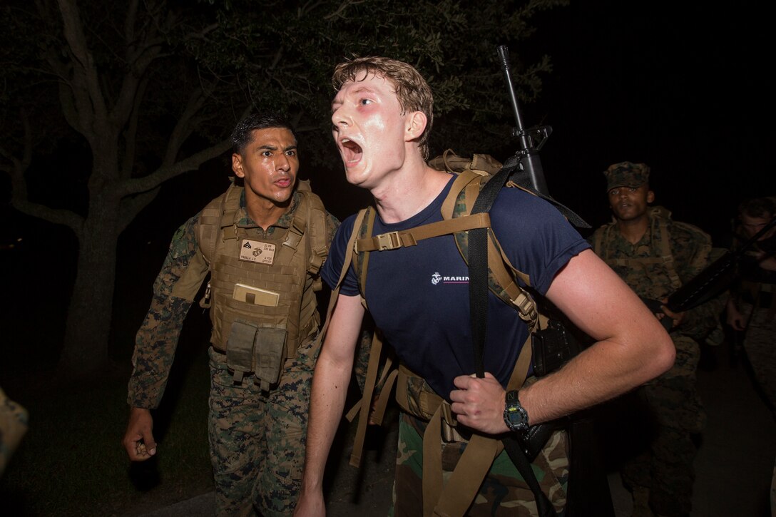 Cpl. Juan C. Padilla, a training non-commissioned officer with S-3, Headquarters Battalion, Marine Forces Reserve, yells at a Naval Reserve Officers Training Corps Midshipmen from the Platoon Leadership Course to keep up during a 10 kilometer hike around an Armed Forces Reserve Center in Baton Rouge, La., October 20, 2018. Marines from Marine Forces Reserve, in New Orleans, assisted in the hike to provide personal experiences and motivation for midshipman to better prepare them for Officer Candidate School and for their future military careers. (U.S. Marine Corps photo by Cpl. Niles Lee)