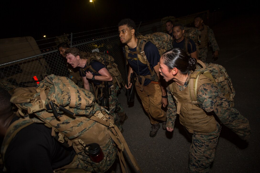 Sgt. Maria Dewey, a drum major with the Marine Forces Reserve Band, yells at a Naval Reserve Officers Training Corps Midshipmen from the Platoon Leadership Course to keep up during a 10 kilometer hike around an Armed Forces Reserve Center in Baton Rouge, La., October 20, 2018. Marines from Marine Forces Reserve, in New Orleans, assisted in the hike to provide personal experiences and motivation for midshipman to better prepare them for Officer Candidate School and for their future military careers. (U.S. Marine Corps photo by Cpl. Niles Lee)