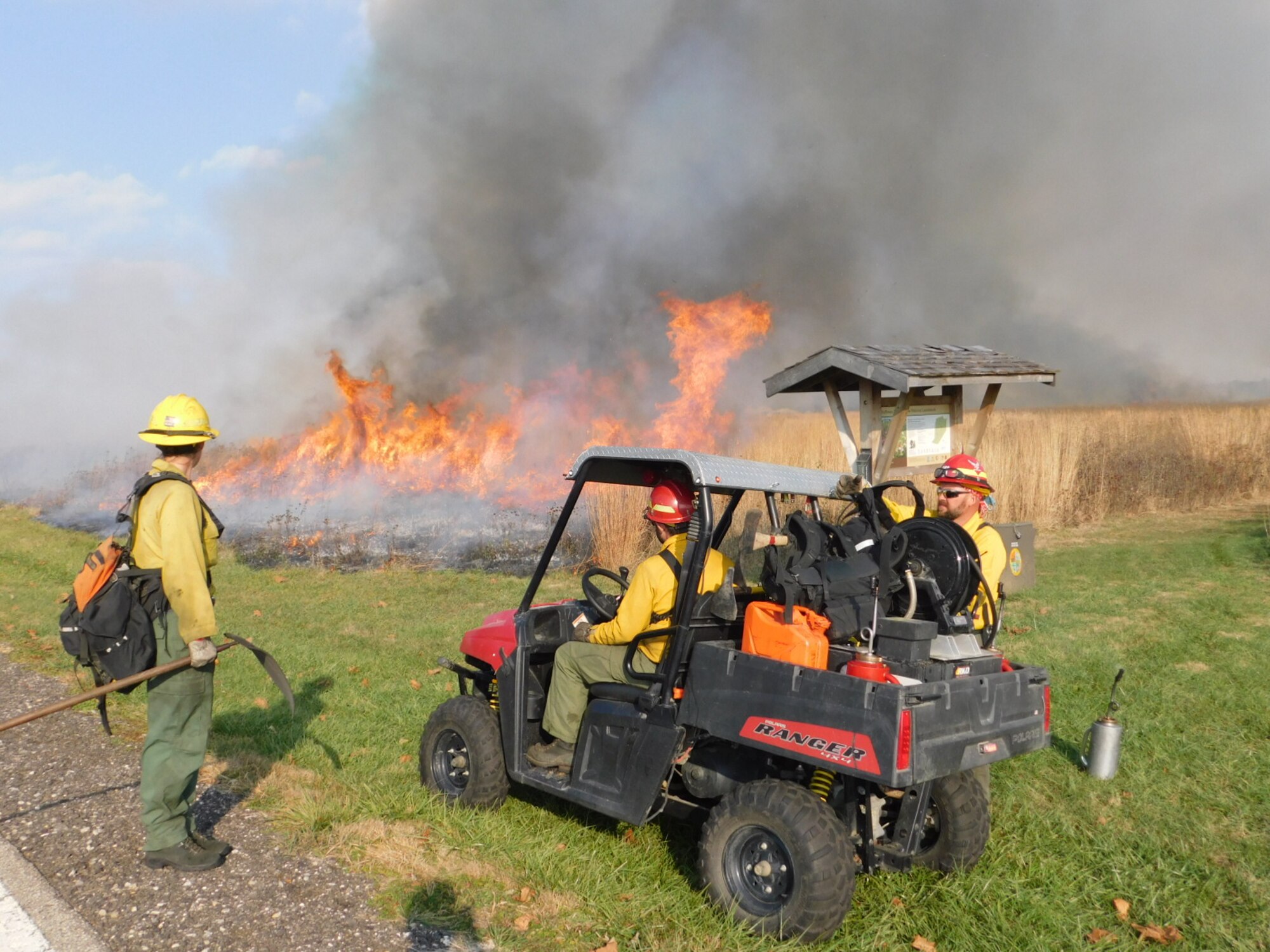 Darryn Warner, Natural Resources Program Manager, right, and personnel from the U.S. Fish and Wildlife Service Big Oaks Wildlife Refuge monitor a prescribed burn at the Huffman Prairie in 2016. (Courtesy photo)