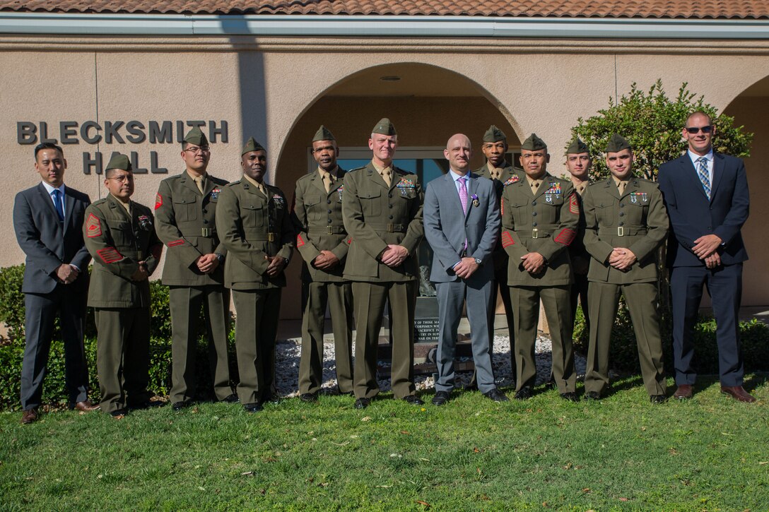 Marine veteran Matthew R. Follett (center) poses for a photo with Marine guests and Marines with 2nd Battalion, 23rd Marine Regiment, 4th Marine Division, after he was presented with a Purple Heart in Pasadena, Calif. on October 19, 2018. SSgt Follett received the award for injuries sustained while serving as an active duty counter intelligence specialist with 3rd Battalion, 4th Marine Regiment, 1st Marine Division, on January 7, 2010. (U.S.  Marine Corps photo by Lance Cpl. Samantha Schwoch/released)