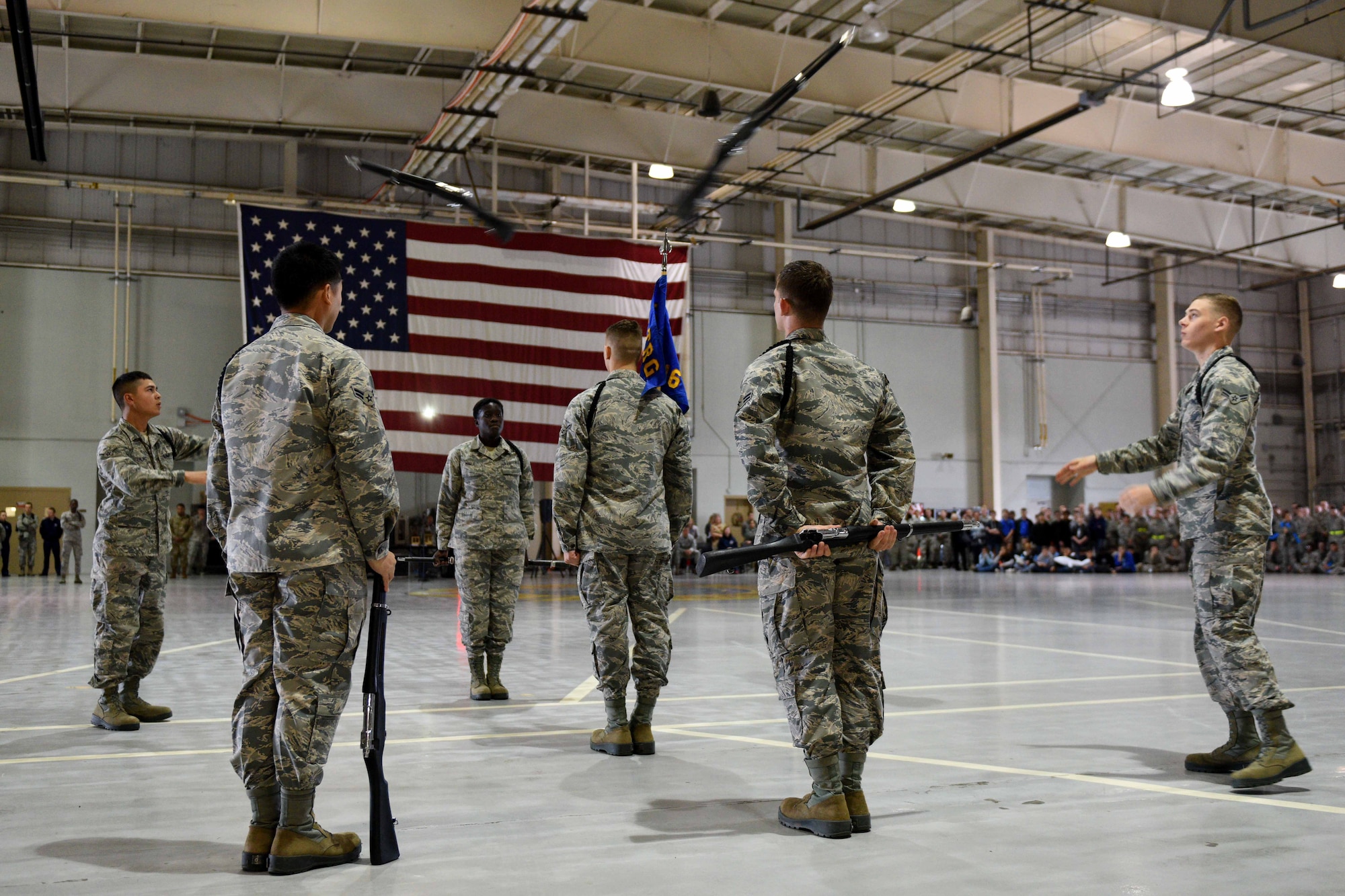 Airmen from the 316th Training Squadron perform an exhibition drill during the quarterly drill competition at the Louis F. Garland Department of Defense Fire Academy on Goodfellow Air Force Base, Texas, Oct. 19, 2018. The Airmen march with, spin and throw decorative rifles. (U.S. Air Force photo by Senior Airman Randall Moose/Released)