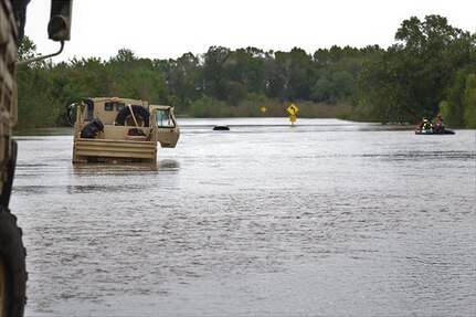 Texas National Guardsmen support vehicles approach a flooded roadway near Huntsville, Texas, Oct. 18, 2018.  Texas Guardsmen worked alongside emergency first responders to help Texans in need during severe flooding.