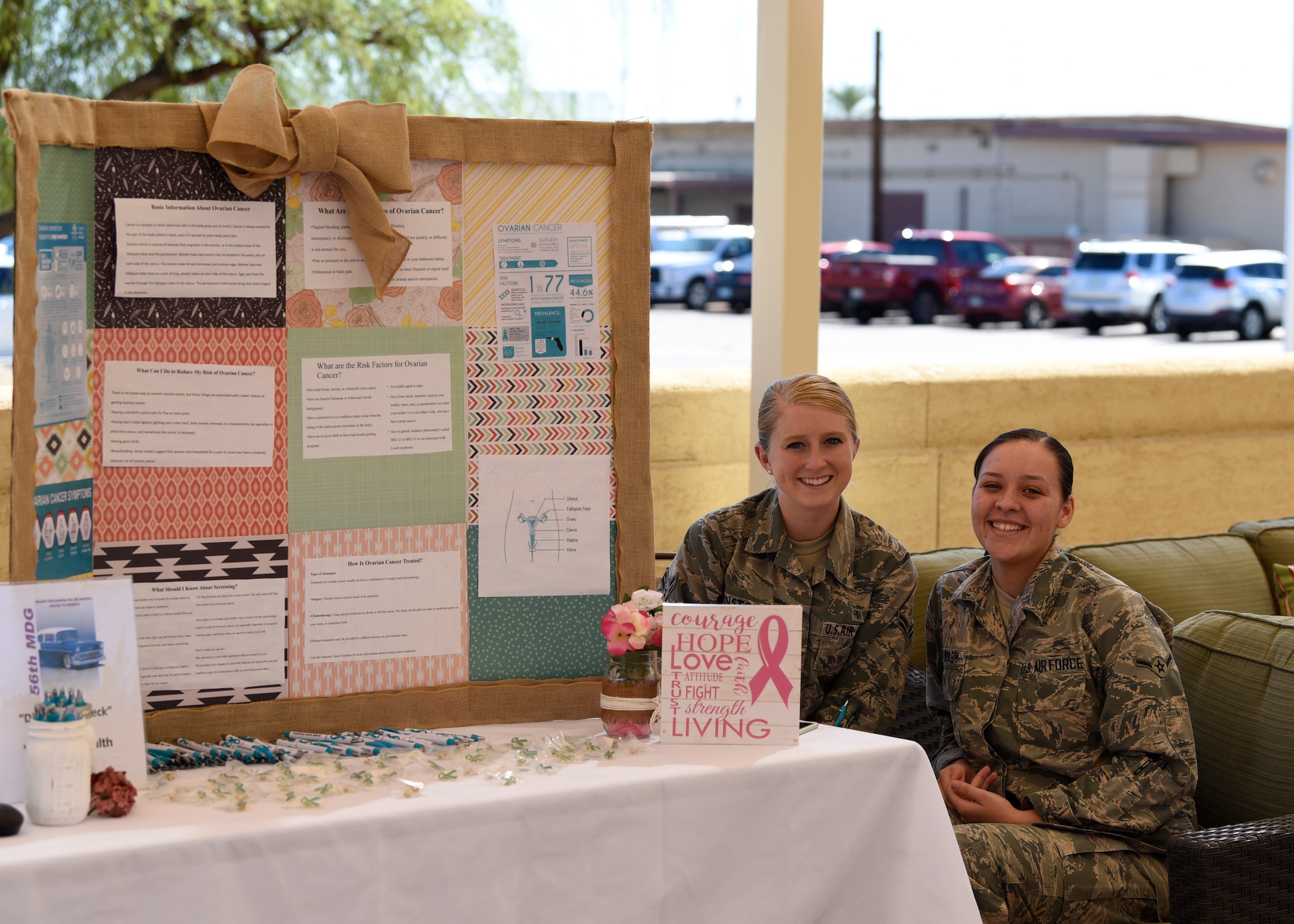 Airmen assigned to the 56th Medical Group wait by their booth during the “Tune up for Health” health fair and car show to educate attendees about the importance of reducing the risk of cancer, Oct. 19, 2018 at Luke Air Force Base, Ariz.