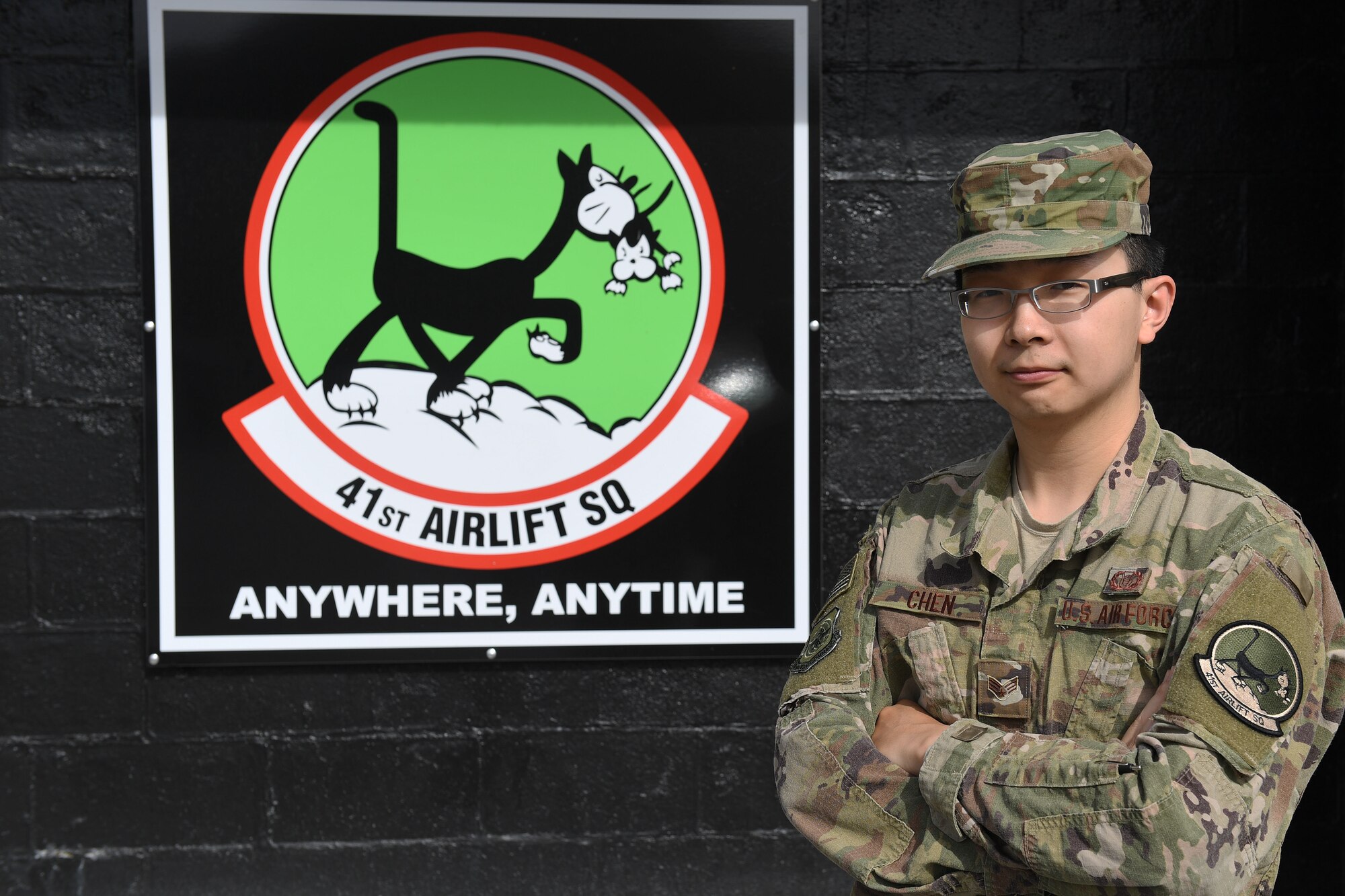 A man stands in front of a symbol of a cat.