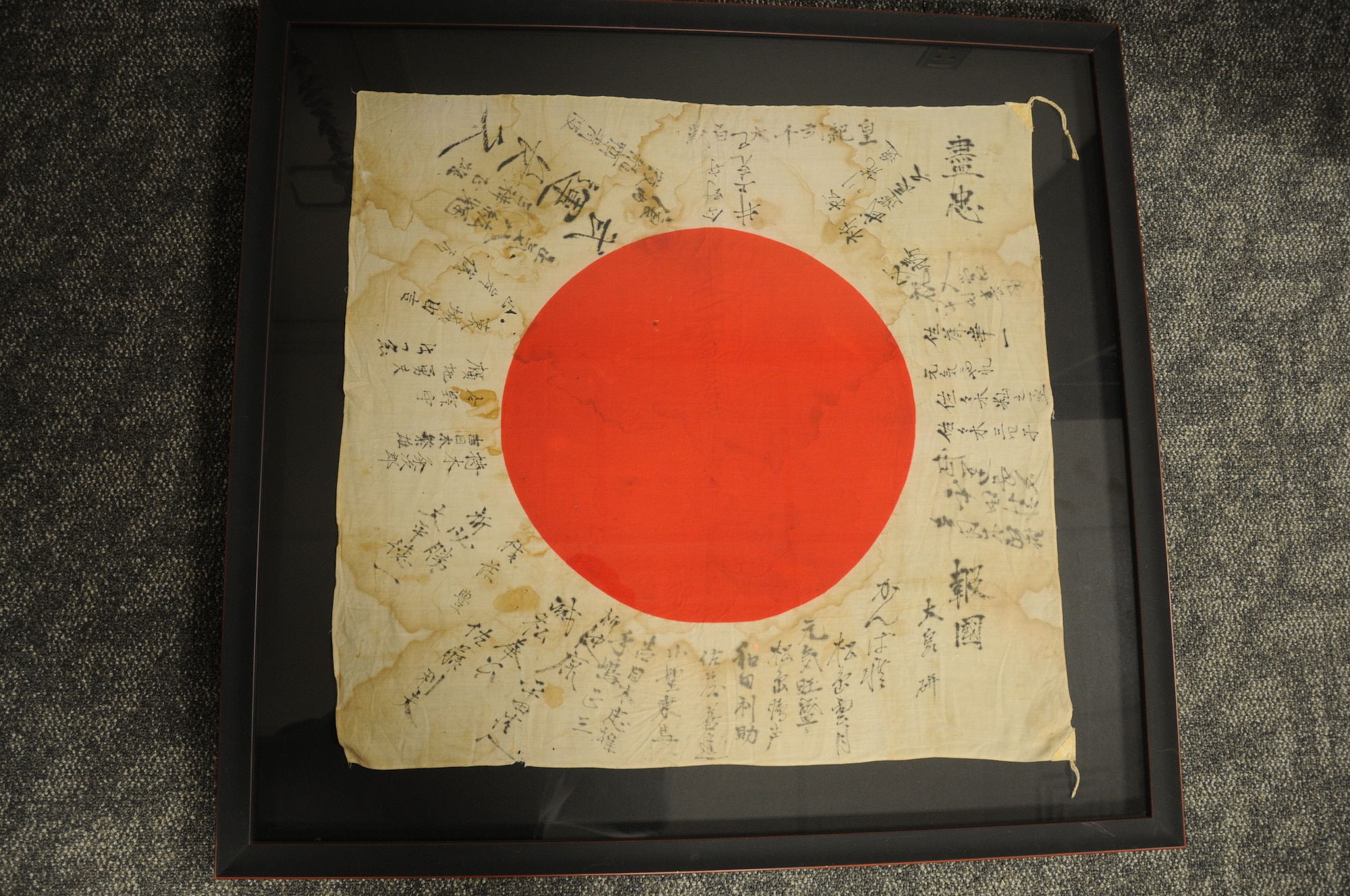 Fitted in a frame for preservation, Dr. Jordan is both haunted and intrigued by the tattered Japanese war flag.
