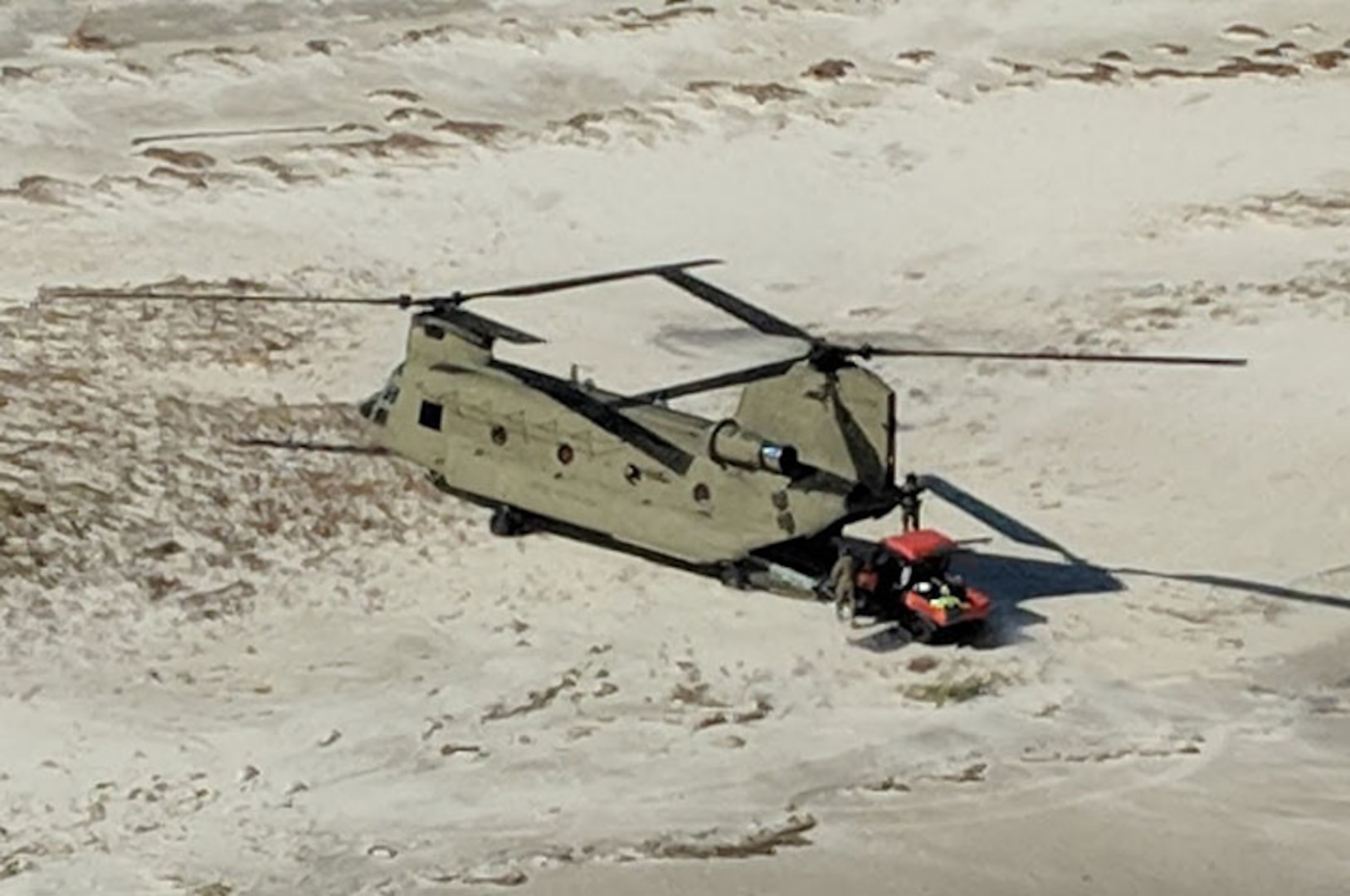 A New York Army National Guard CH-47 Chinook helicopter transports search and rescue personnel and their all-terrain vehicles to St. Teresa, along the shoreline of the Florida panhandle, Oct. 12, 2018. The New York Army National Guard Soldiers deployed two Chinooks and two UH-60 Black Hawk helicopters along with 25 crew members to Tallahassee, Florida, to assist with response and recovery efforts for the Florida National Guard following the impact of Hurricane Michael.