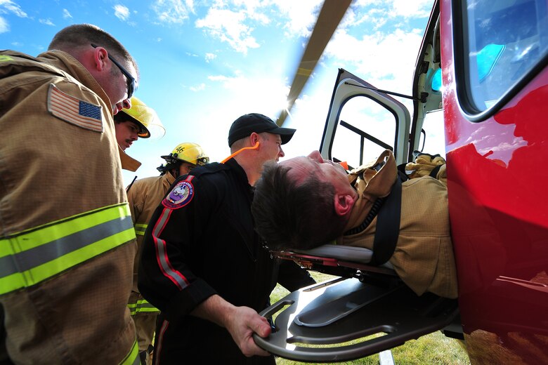 Schriever Fire Department firefighters assist life flight aircrew in loading a patient onto the life flight helicopter during Opinicus Vista 18-2 at Schriever Air Force Base, Colorado, Oct. 17, 2018. Exercises give base personnel an opportunity to practice responding to a becoming more proficient, should a real world situation occur. (U.S. Air Force Photo by Dennis Rogers)