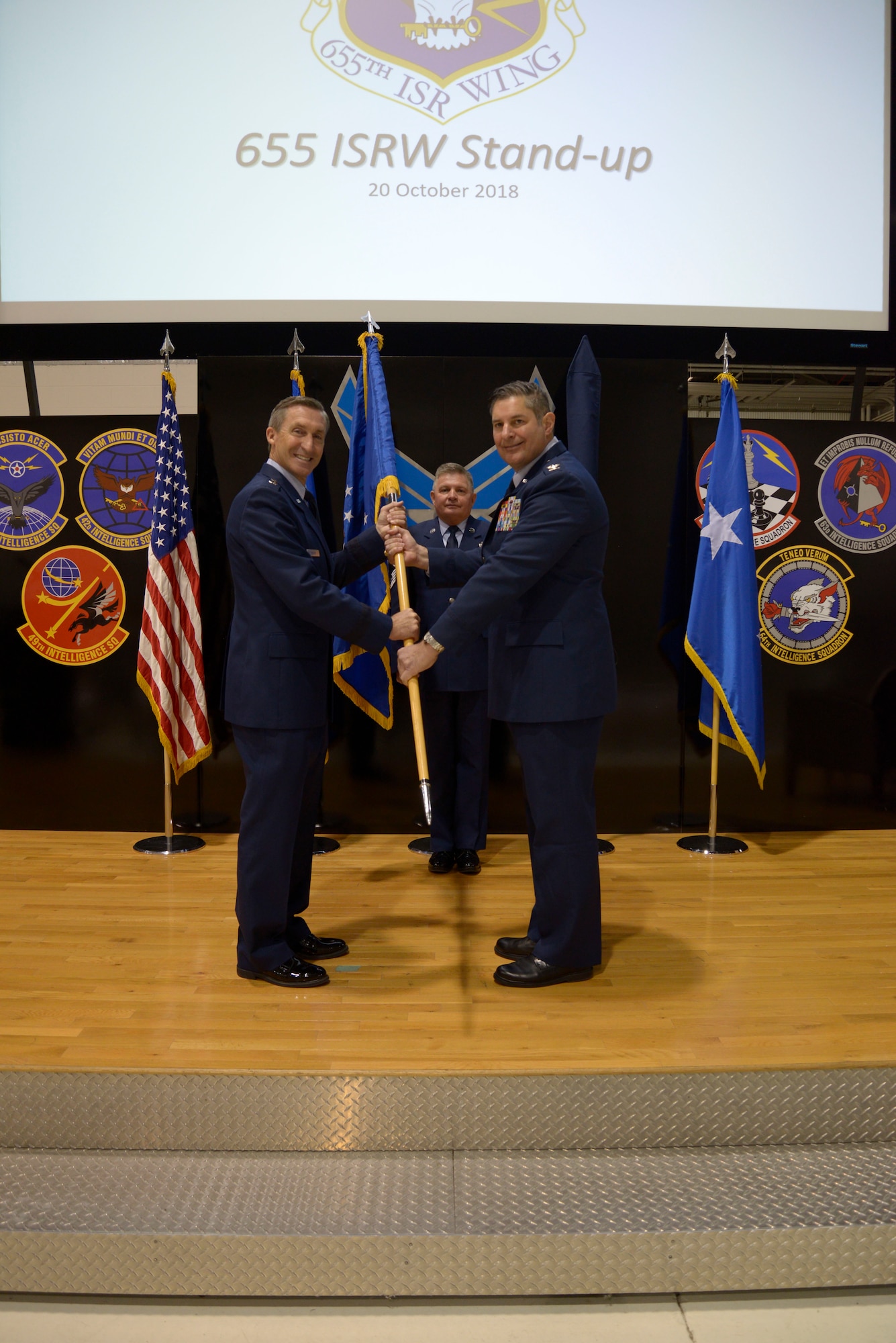 Maj. Gen. Ronald B. Miller, 10th Air Force commander, passes the guidon to Col. John D. McKaye, 655th Intelligence, Surveillance, and Reconnaissance Wing provisional commander, during the 655th ISRW Stand-up ceremony here Oct. 20, 2018. The 655th ISRW encompasses two groups, the 655th ISRG, located here, and the 755th ISRG, located at Joint Base Langley-Eustis, Virginia, and 14 squadrons over seven operating locations engaged in 10 distinct mission sets. (U.S. Air Force photo/Senior Airman Holly Ardern)