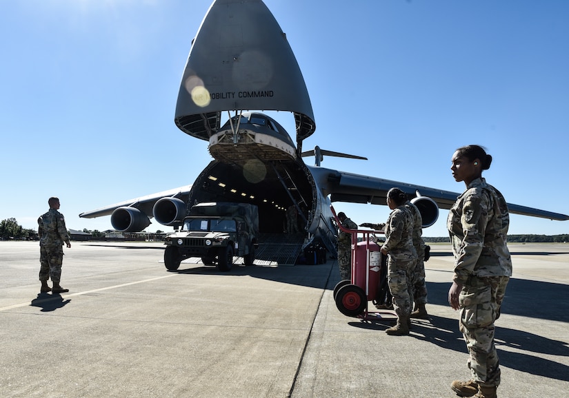 U.S. Army Soldiers assigned to the 119th Inland Cargo Transfer Company, 11th Transportation Battalion, 7th Transportation Brigade (Expeditionary) guide vehicles onto a U.S. Air Force C-5M Super Galaxy during a training exercise at Joint Base Langley-Eustis, Virginia, Oct. 18, 2018.