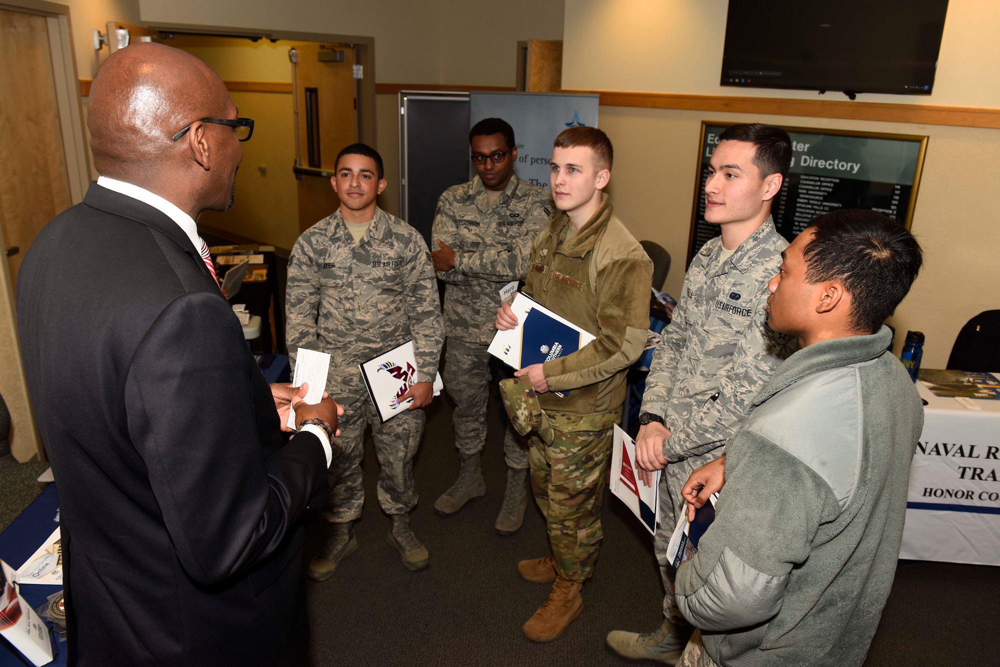 A group of Airmen listen to a college representative about opportunities in furthering education at the 2018 Fairchild Air Force Base Education Fair at Fairchild Air Force Base, Washington, Oct. 18, 2018. The education center houses five different univiersities and colleges allowing Airmen the opportunity to further their education. (U.S. Air Force photo/ Airman 1st Class Lawrence Sena)