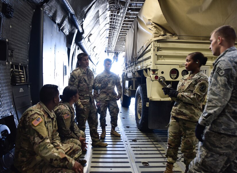 U.S. Army Soldiers from Headquarters and Headquarters Company, 11th Transportation Battalion, 7th Transportation Brigade (Expeditionary), work with U.S. Air Force Airmen from the 733rd Logistics Readiness Squadron to load cargo onto a C-5M Super Galaxy from the 9th Airlift Squadron from Dover Air Force Base, Delaware during a training exercise at Joint Base Langley-Eustis, Virginia, Oct. 19, 2018.