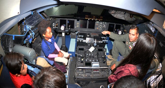 Maj. Brian L. Biggerstaff, 68th Airlift Squadron pilot, quizzes third-grade students from Meredith Baskin Elementary about aircraft controls on the flight deck of a C-5M Super Galaxy at Joint Base San Antonio-Lackland Oct. 19, 2018.